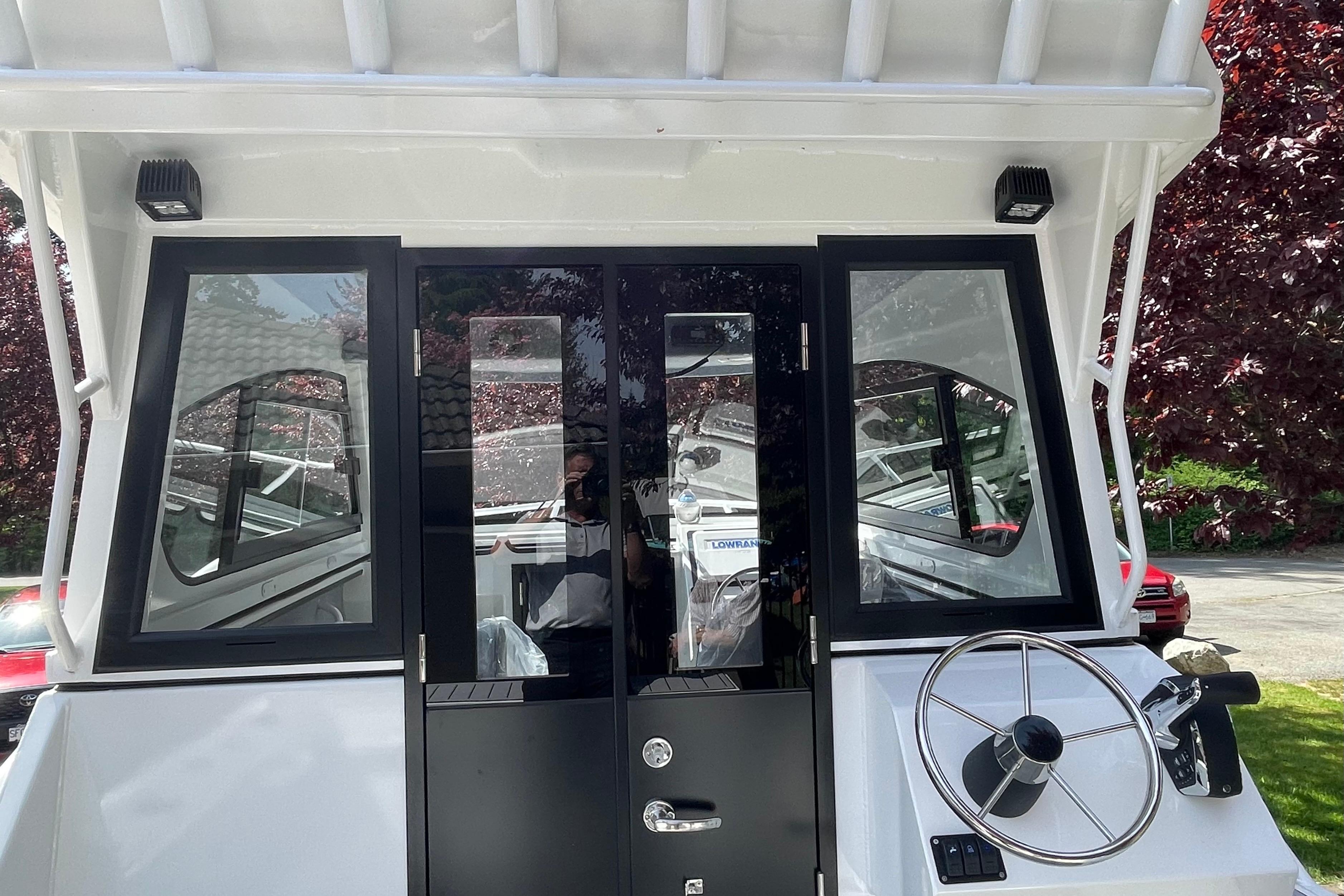 2025 Custom Aluminum 7.5 Profisher boat cockpit with steering wheel and glass doors.