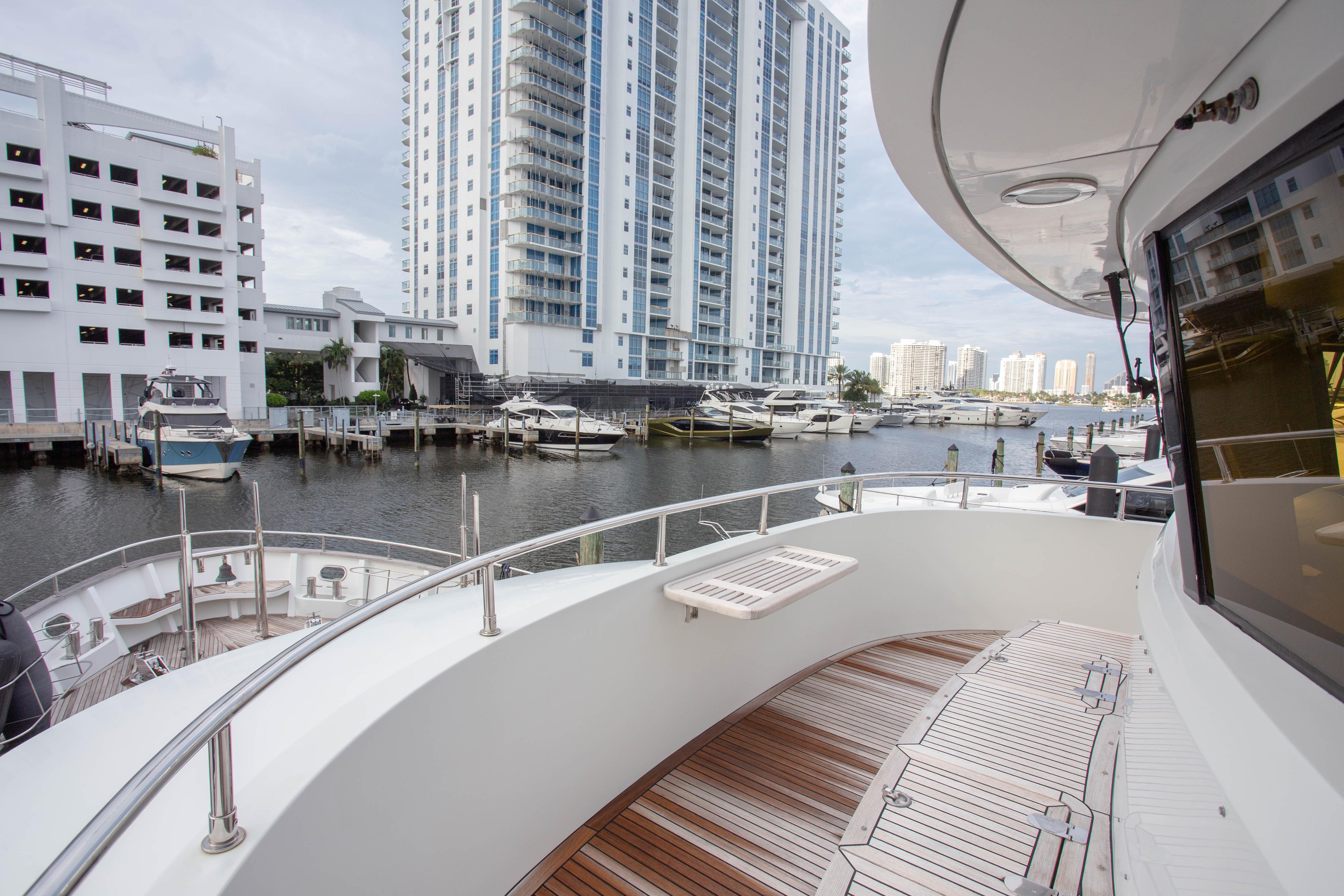 Luxurious 2014 Fifth Ocean Yachts 24m Explorer Yacht docked in urban marina setting.