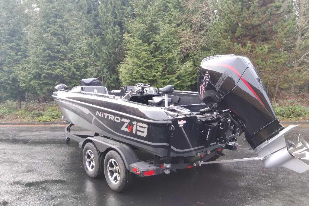 2025 Nitro ZV19 boat on trailer, parked near lush green forest.