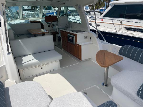 2024 Back Cove 34O yacht interior with seating, table, and kitchenette.