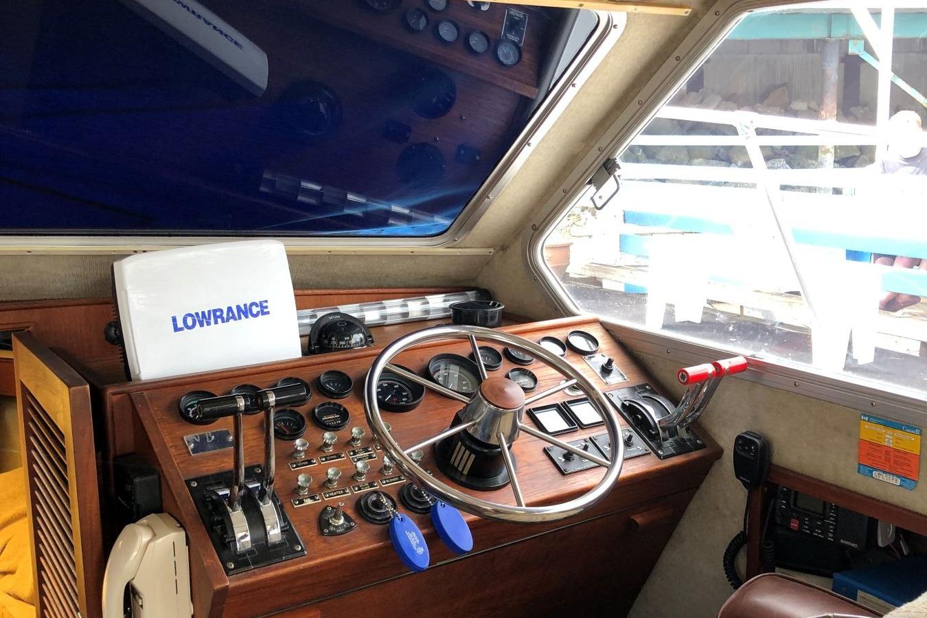 1988 Commander 30 Command Bridge helm with Lowrance equipment and classic wooden dashboard.