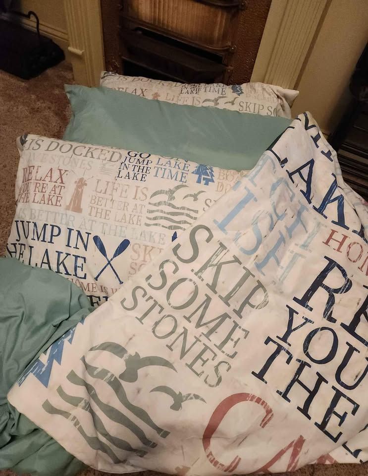Bedding with nautical themes and text in a cozy room.