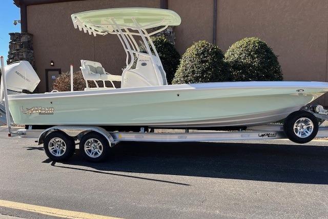 2026 Mako 24 APEX boat on trailer, parked outdoors, side view.