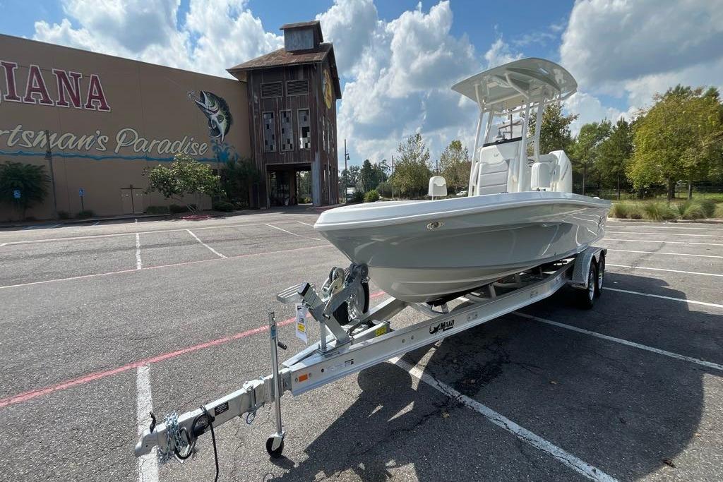 2026 Mako 24 APEX boat on trailer in parking lot, sunny day.