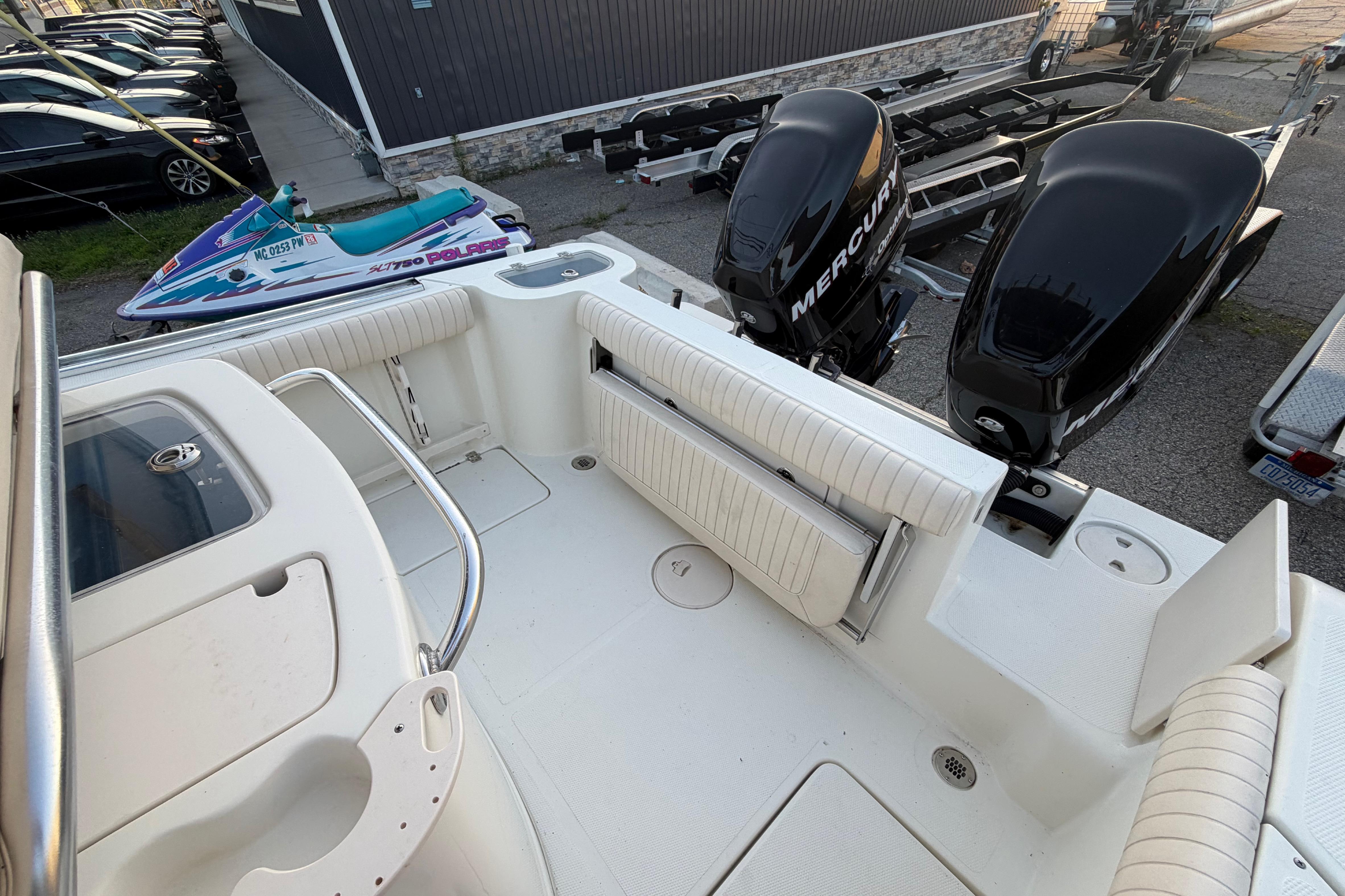 2007 Mako 234 Center Console boat interior with twin Mercury engines and seating area.