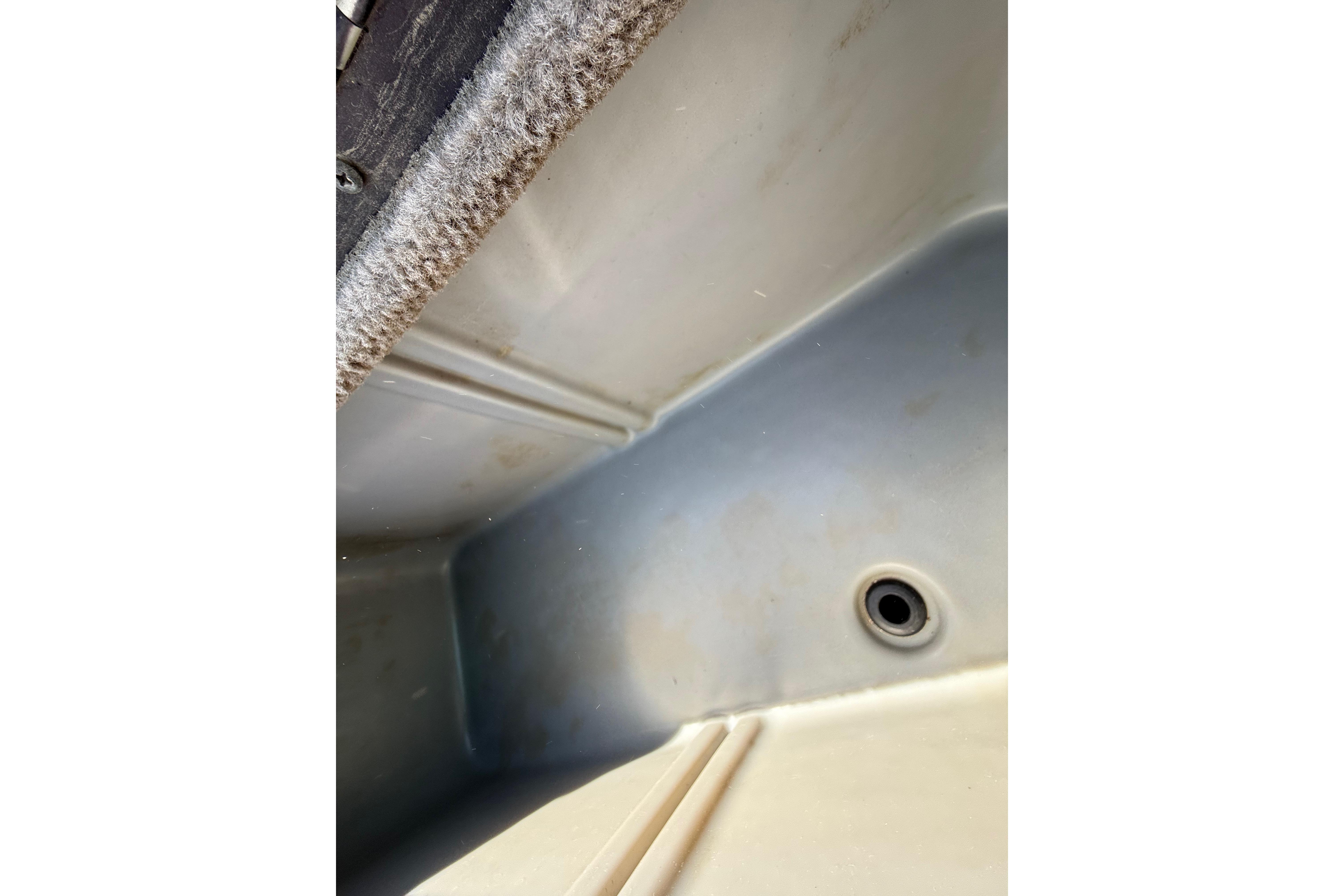 Interior view of a 2010 SeaArk Stealth 190 boat compartment with drain hole.