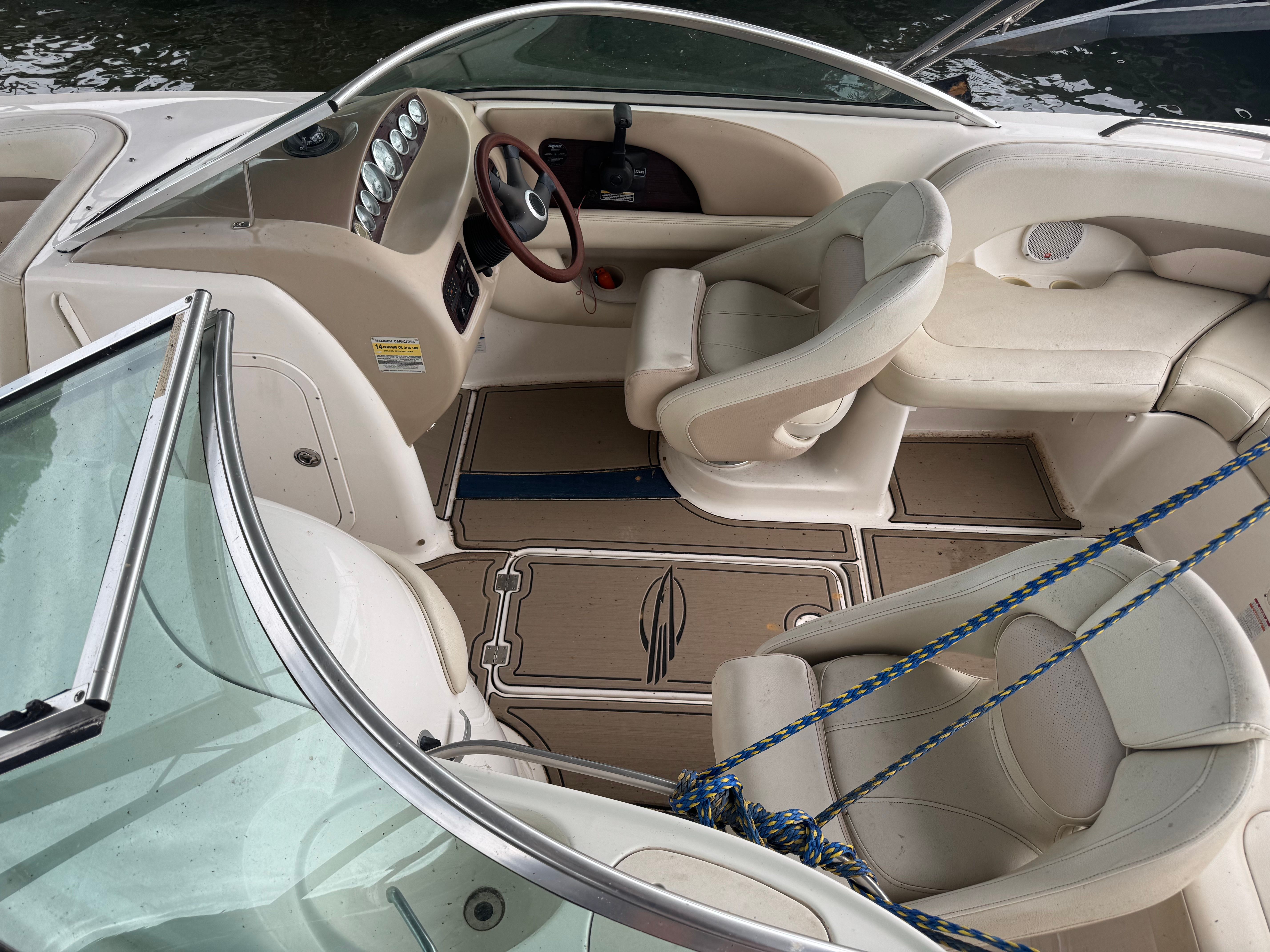 Interior view of a Chaparral Sunesta 223 boat with beige seats and dashboard.