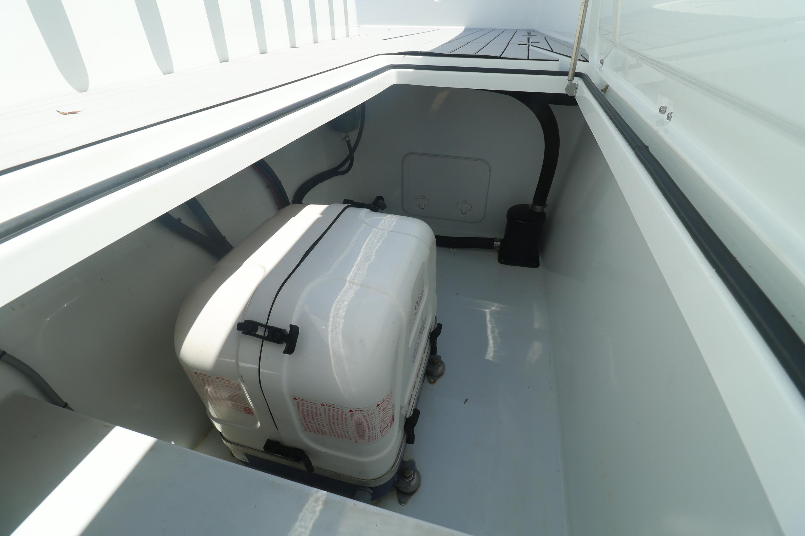 Storage compartment in a 2022 Freeman 47 boat, featuring a secured white container.