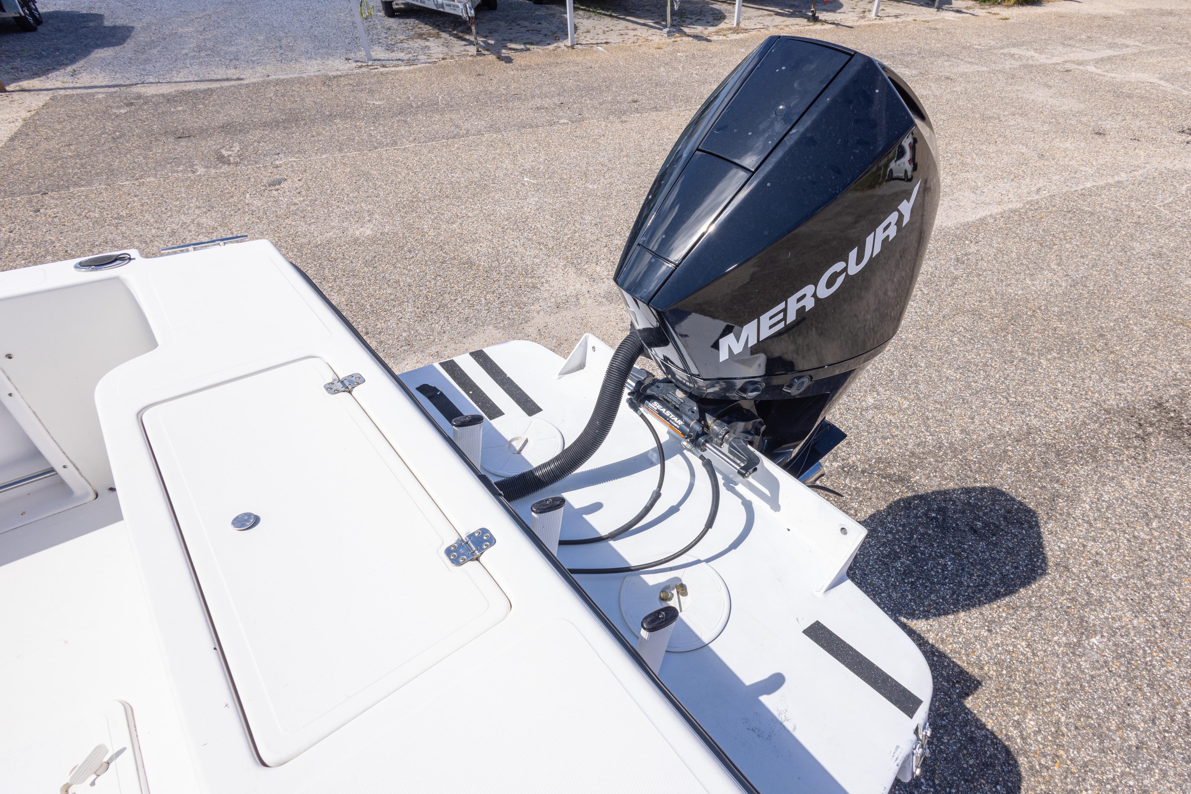 2007 Sea Boss 235 Walkaround boat with Mercury outboard motor, docked on pavement.