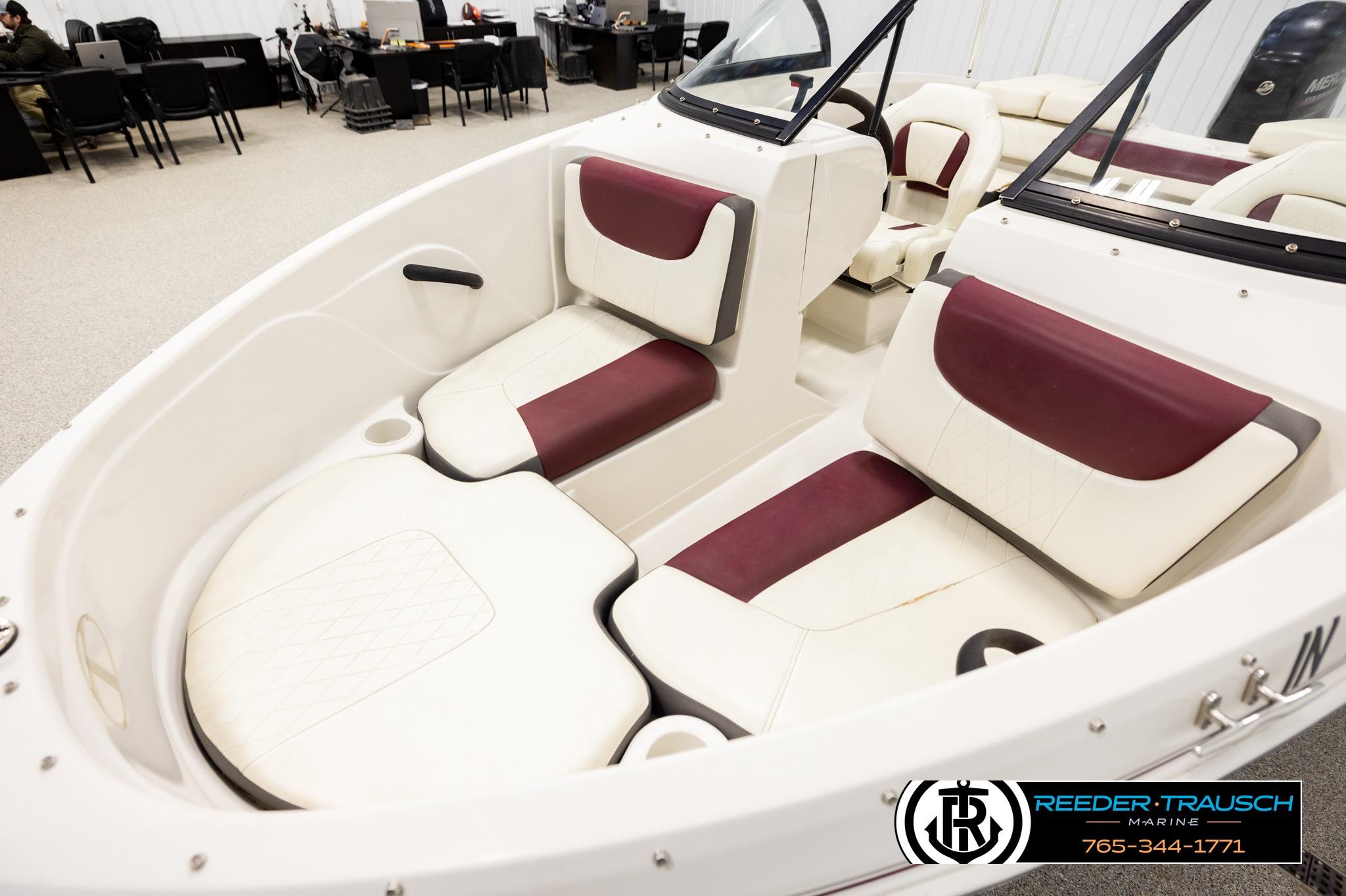 2016 Tahoe 450 TS boat interior with white and maroon seating in showroom.