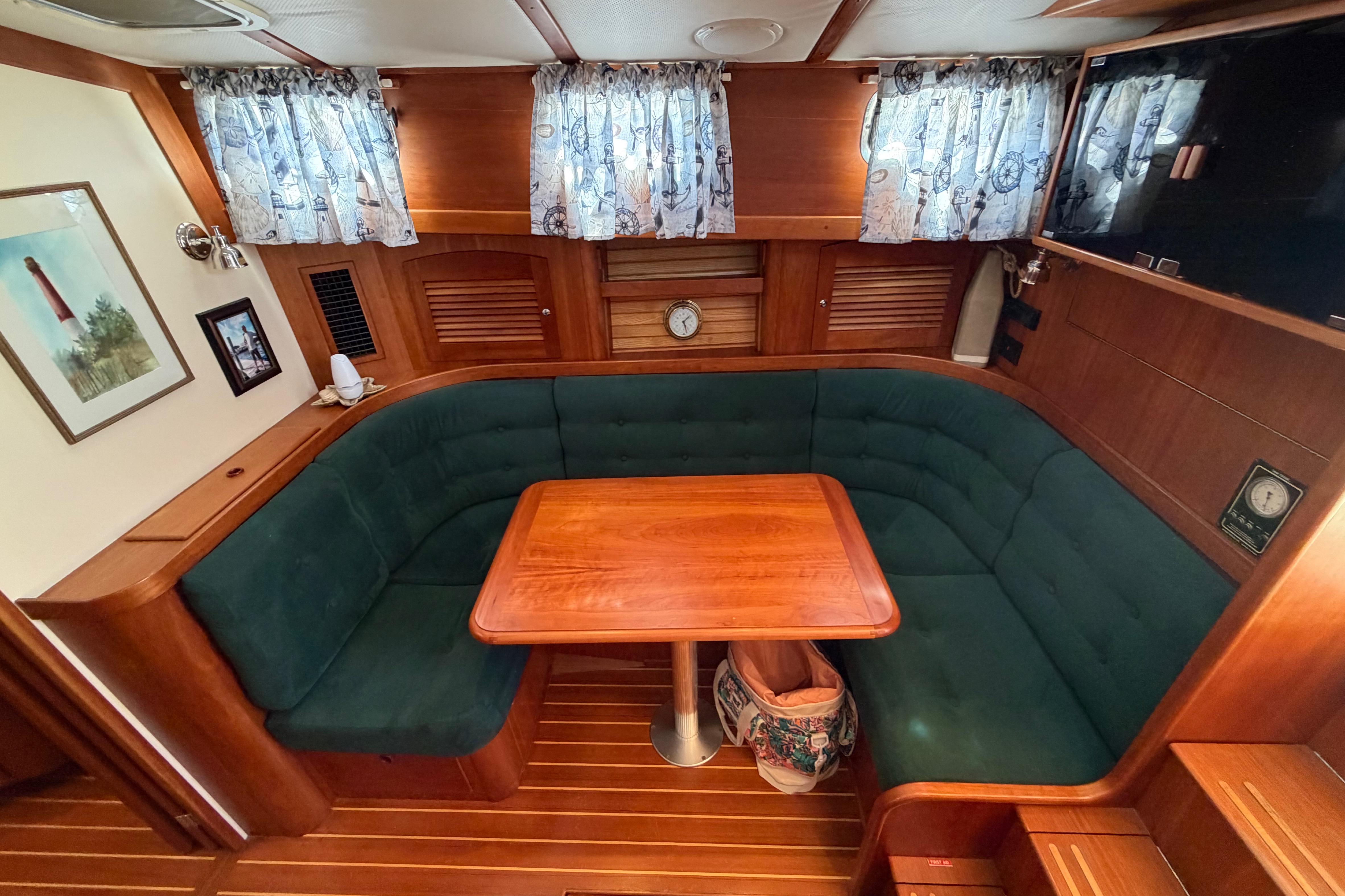 Interior of 2000 Sabreline 36 Express yacht with wooden table and green seating.