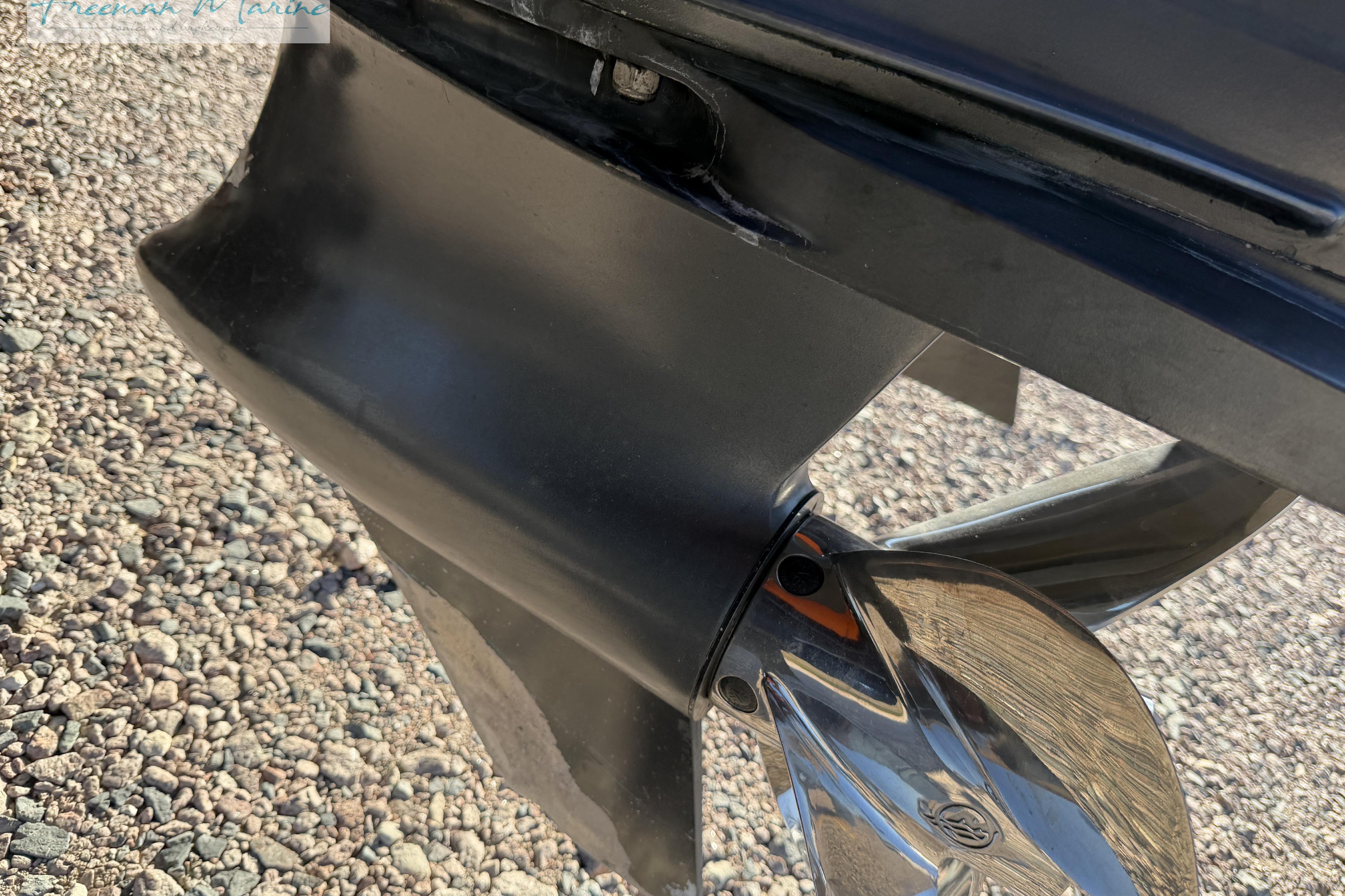 Close-up of a 2020 Midnight Express 43 Open boat propeller on gravel.