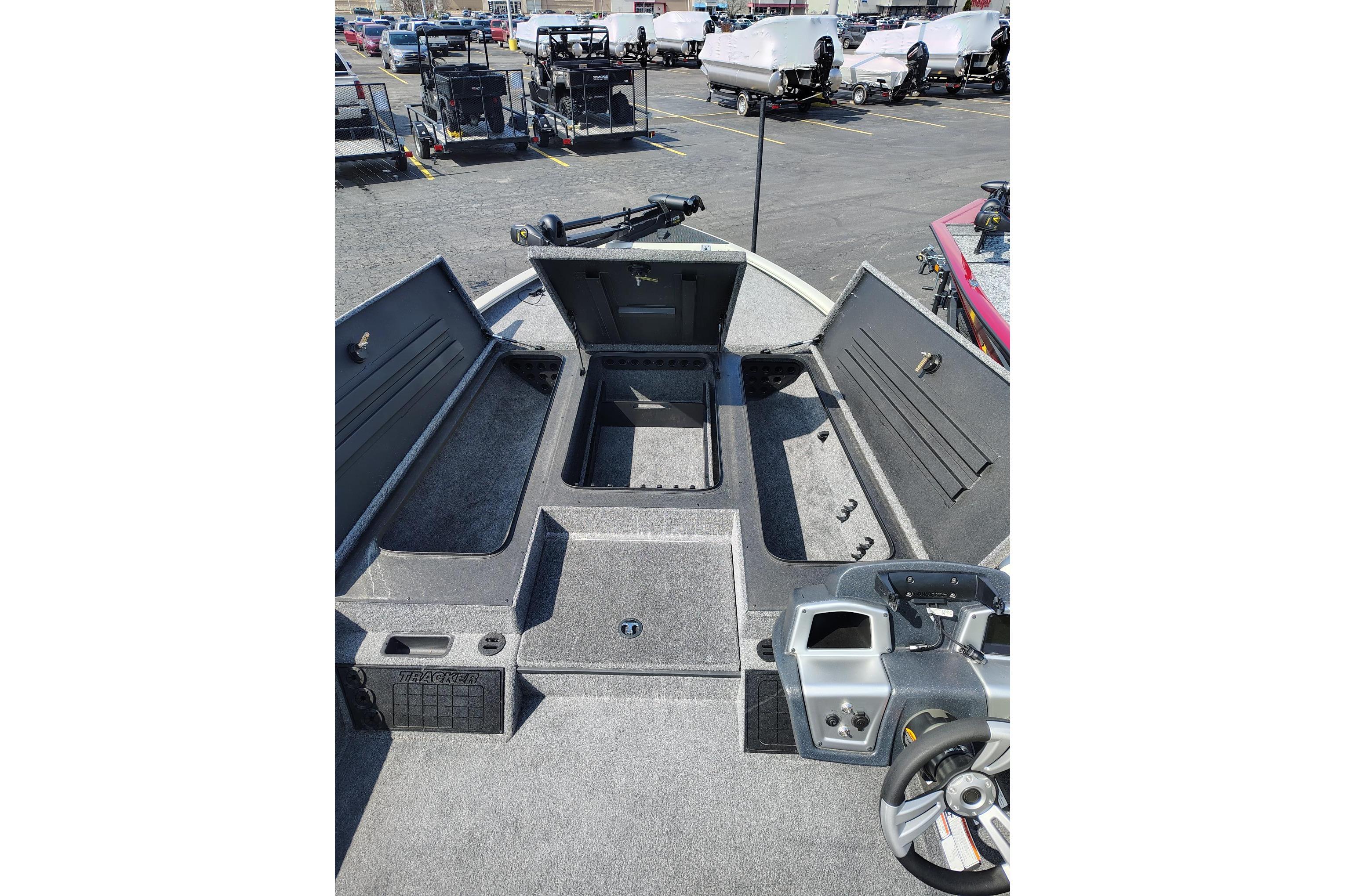 2025 Tracker Savage 215 boat interior with open storage compartments in a parking lot.