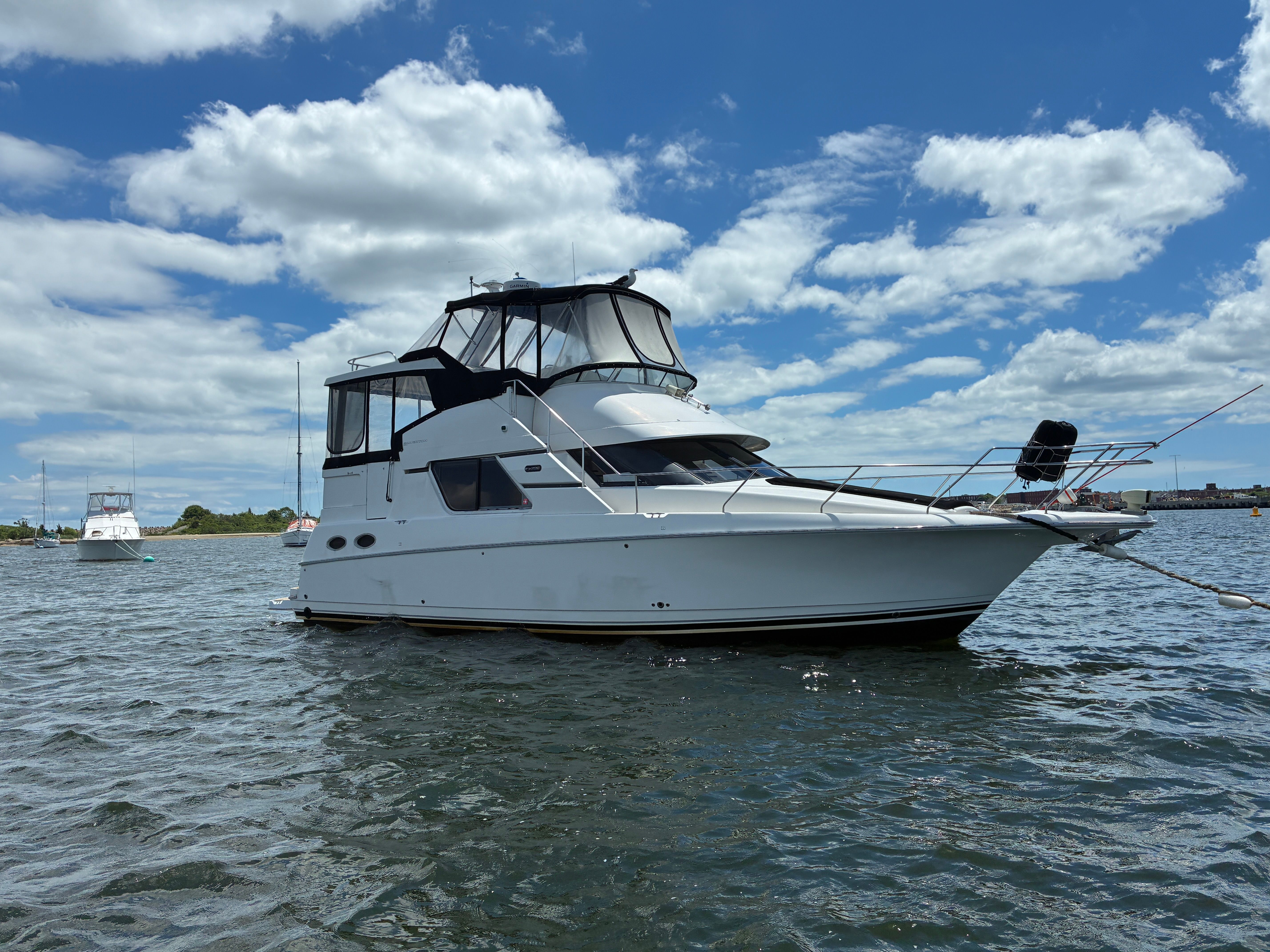 A 2001 Silverton 392 Motor Yacht floats on calm water under a cloudy sky.