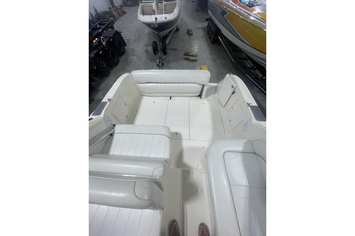 1998 Sea Ray 270 Sundancer boat interior with white seating in a storage facility.