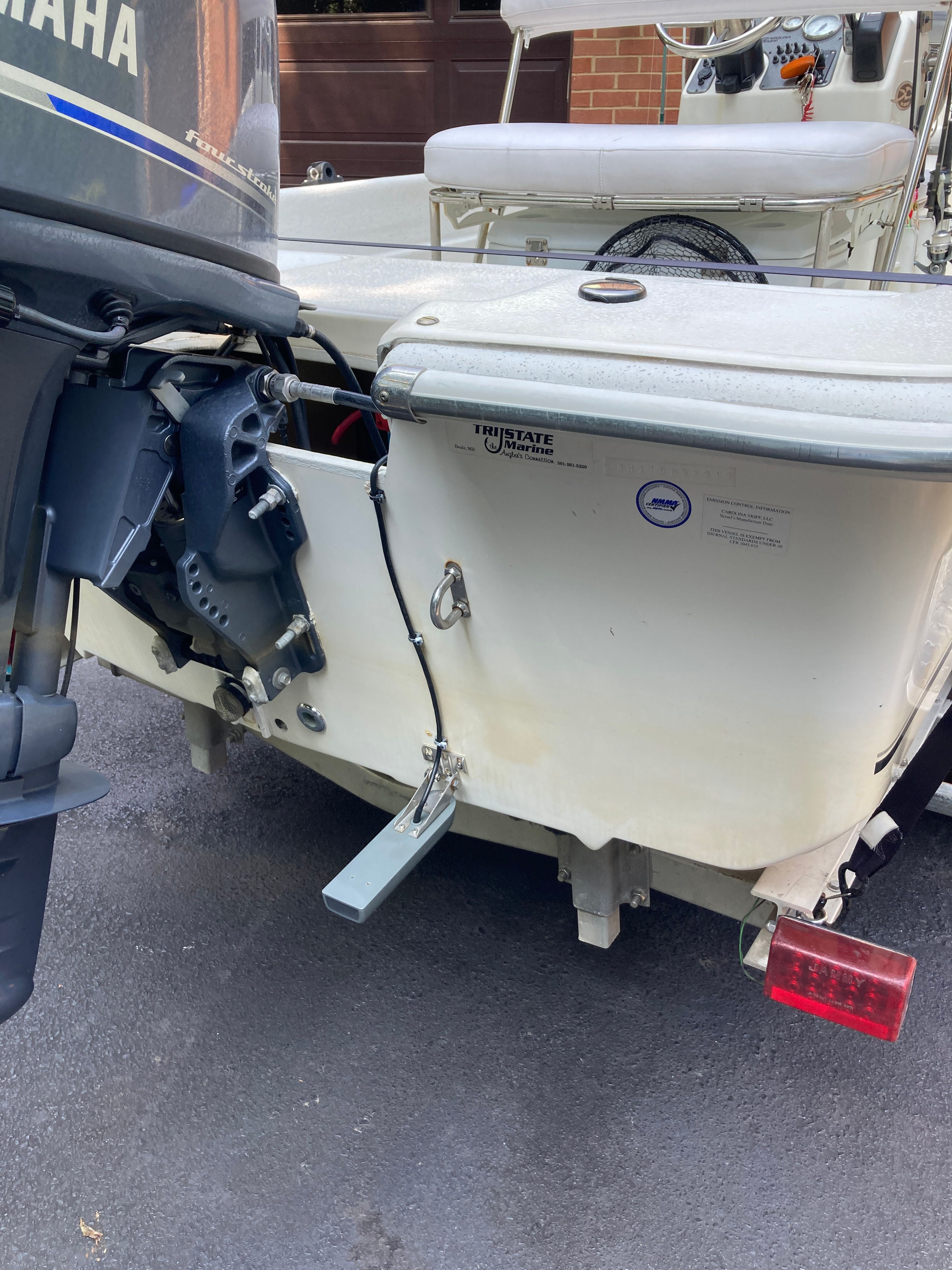 The image shows the stern of a 2012 Carolina Skiff JVX16CC boat with an outboard motor.