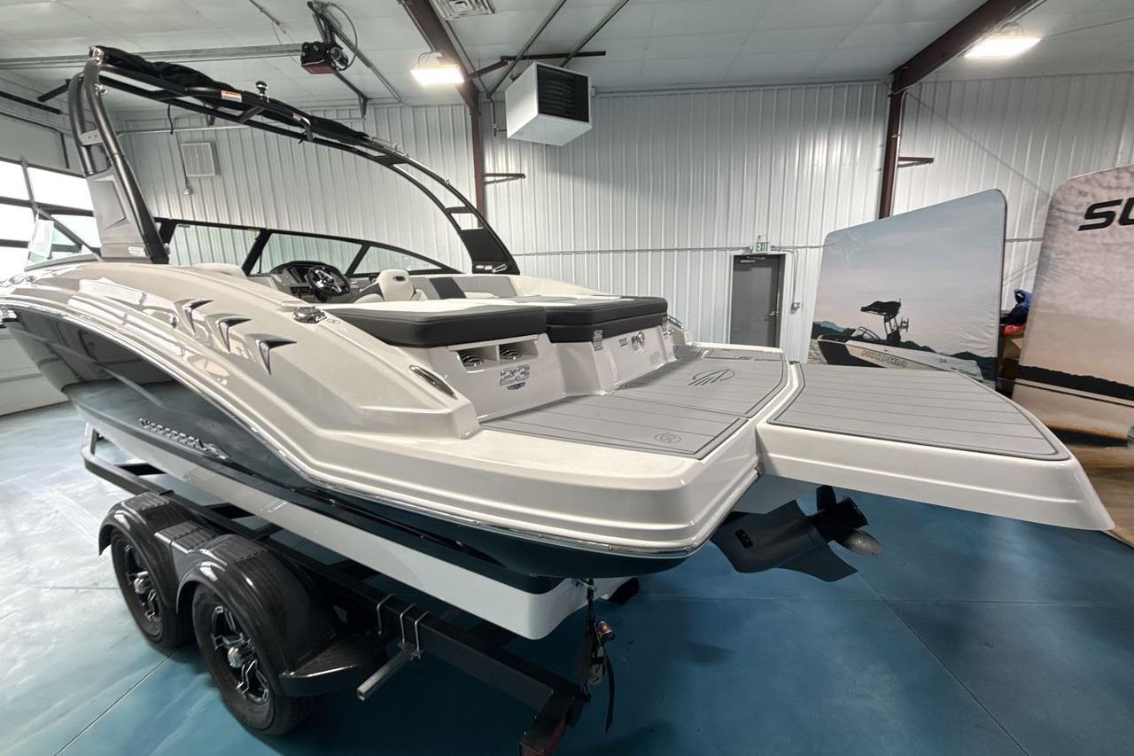 A 2026 Chaparral 23 SSi boat is on a trailer inside a warehouse.
