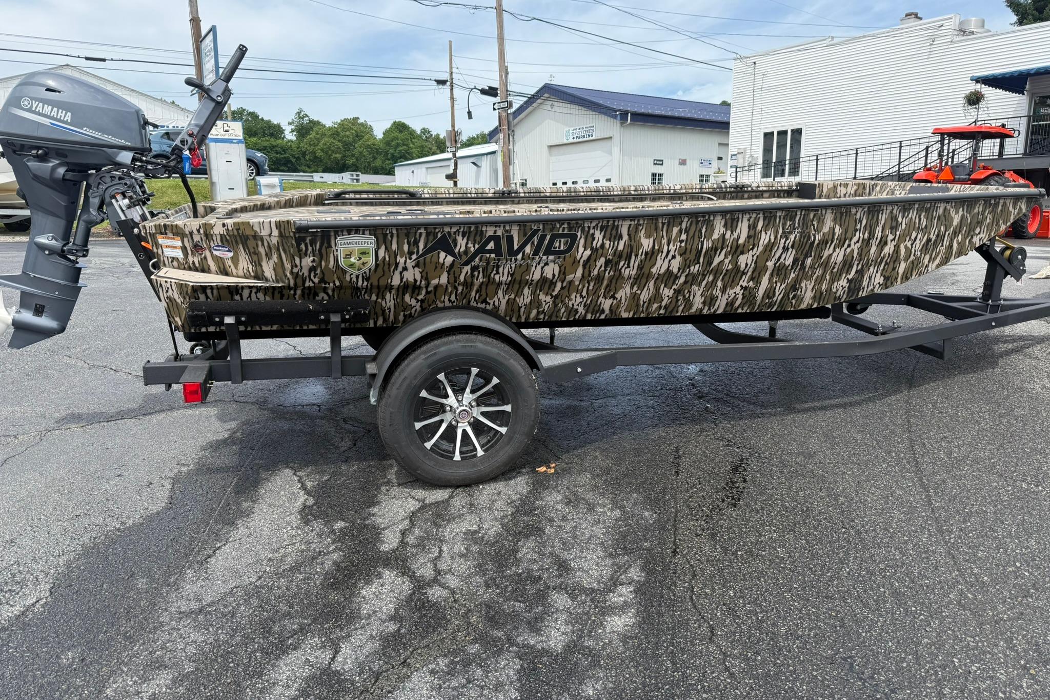 2026 Avid 16 Commander boat with camouflage design on a trailer, featuring a Yamaha outboard motor.