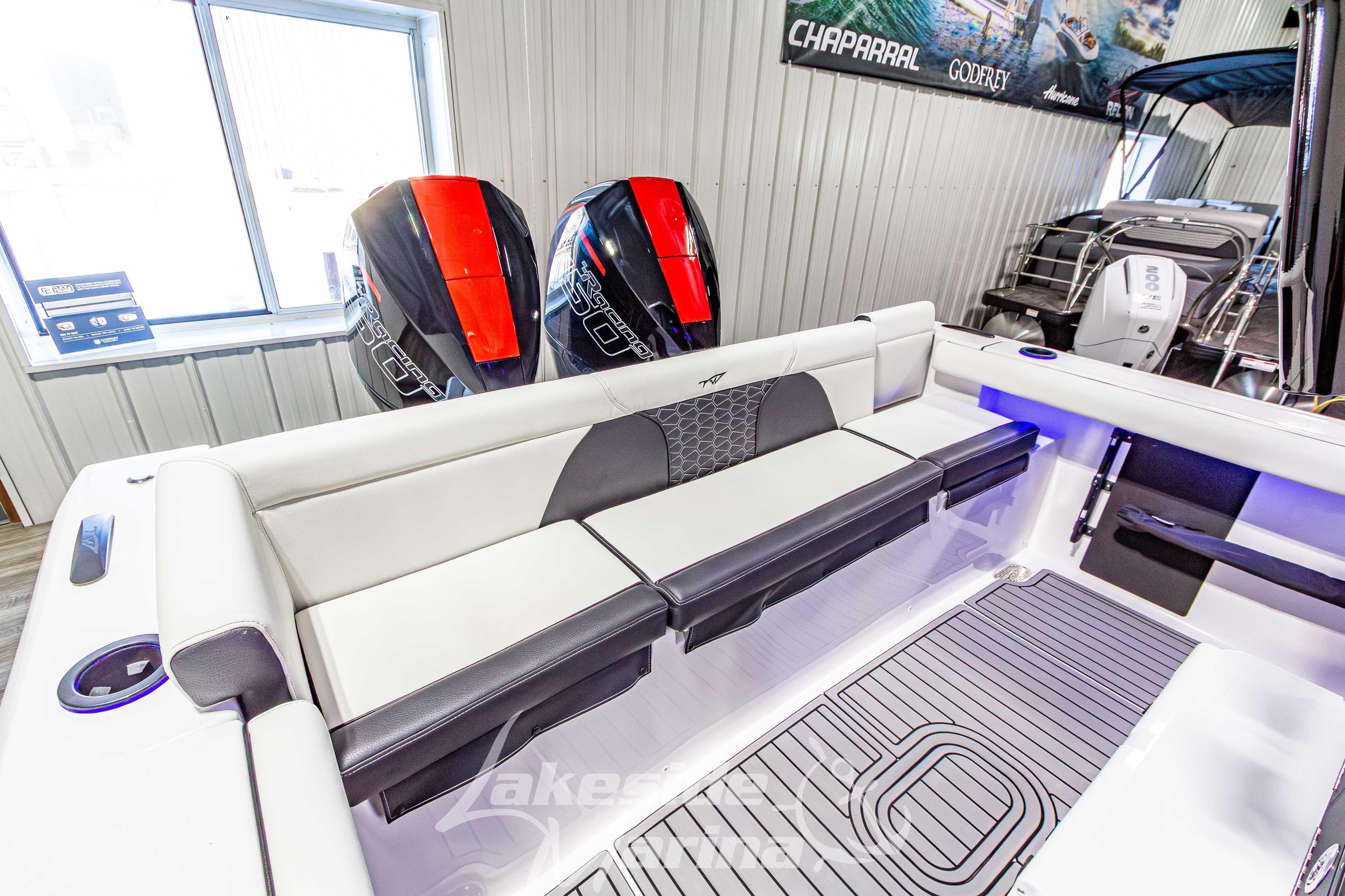 2026 Tidewater 256 LXF boat interior with dual outboard engines in showroom.