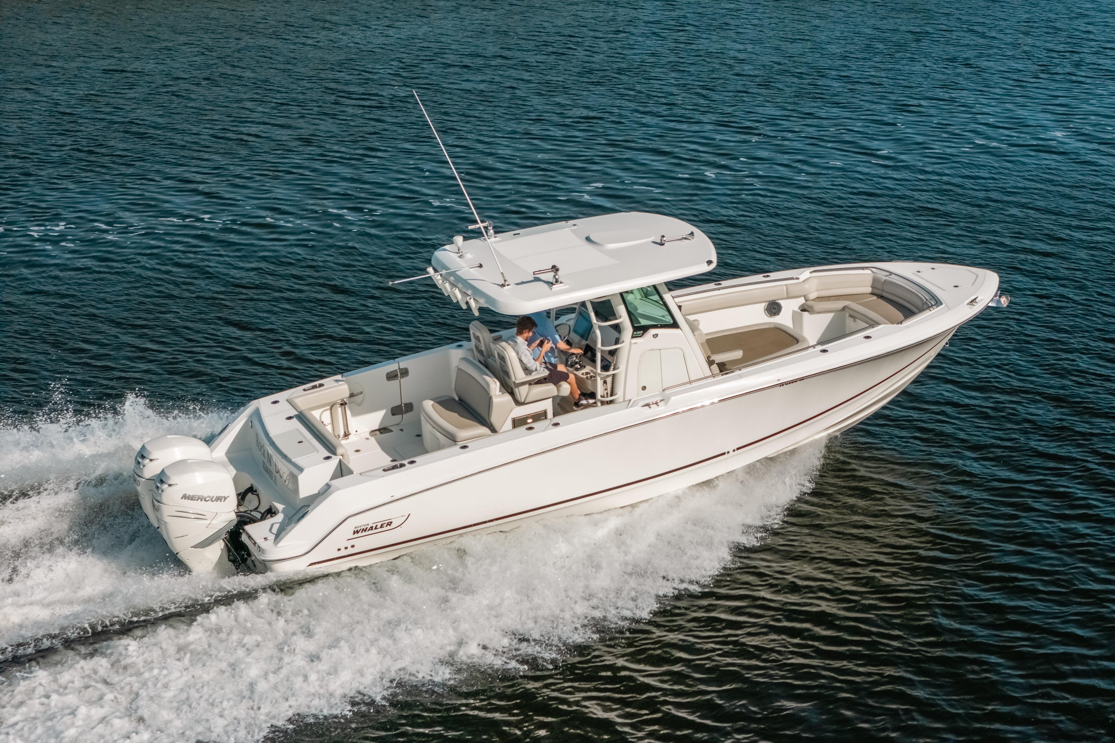 2019 Boston Whaler 330 Outrage cruising on open water, showcasing sleek design and powerful engines.
