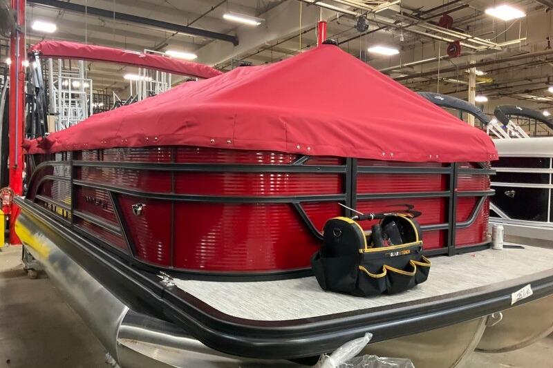 2026 Bennington 22 SSRSF pontoon boat with red cover in a warehouse.