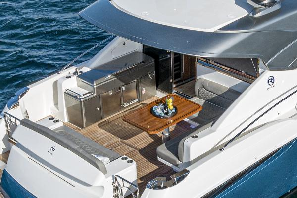 2021 Riviera 5400 Sport Yacht aft deck with dining area and kitchenette.