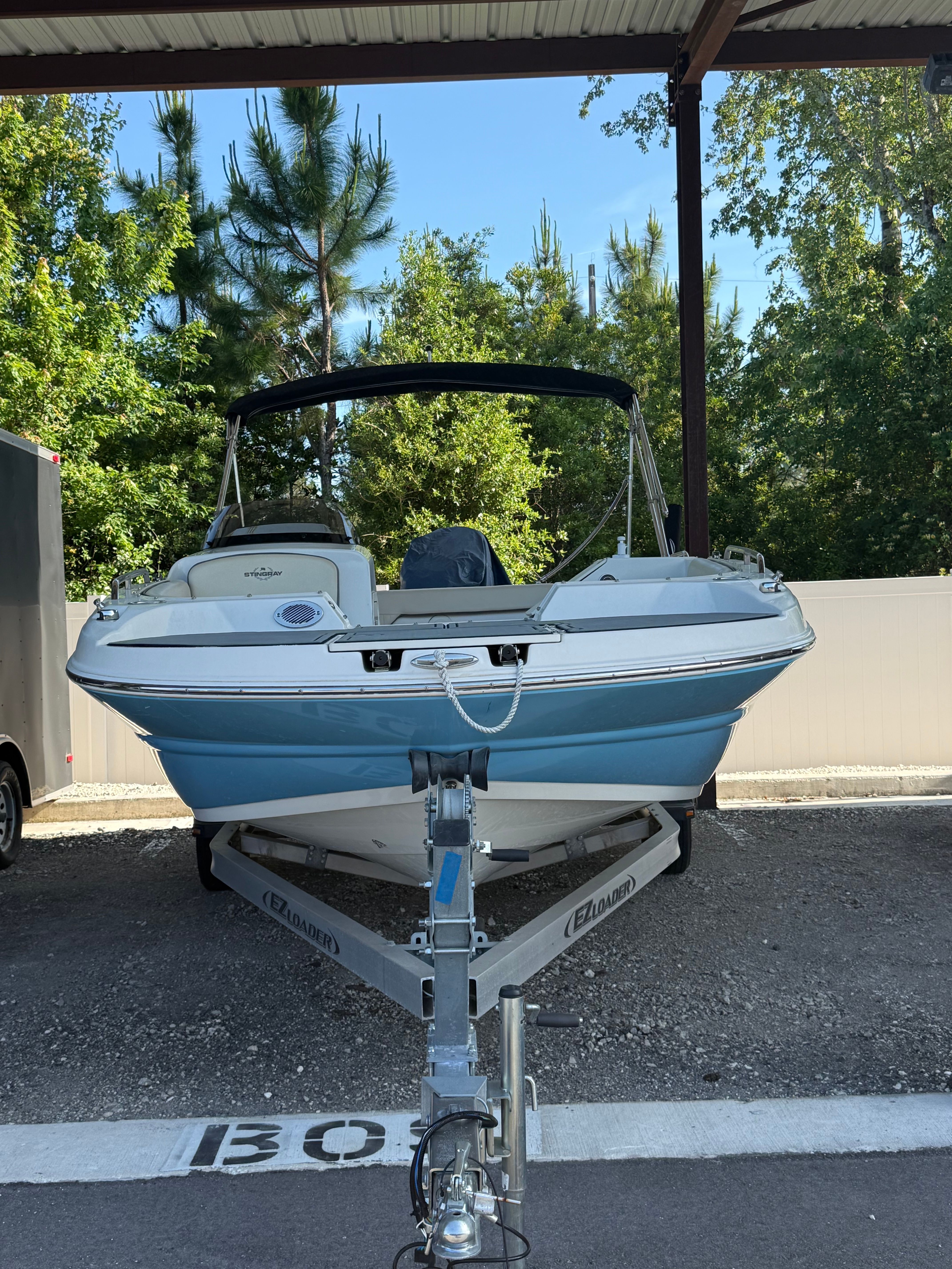 2023 Stingray 192 SC boat on trailer under canopy.