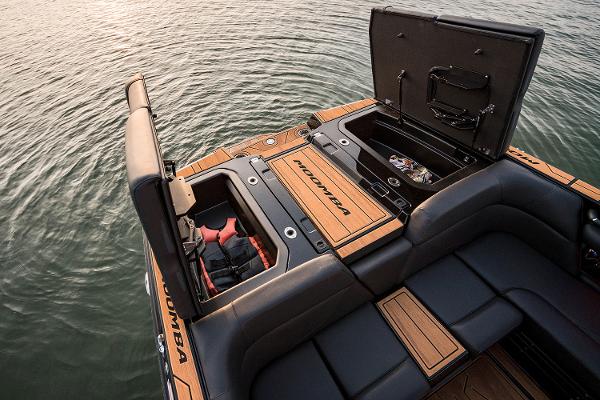 Manufacturer Provided Image: 2025 Moomba Mojo boat with open storage compartments on a calm lake.