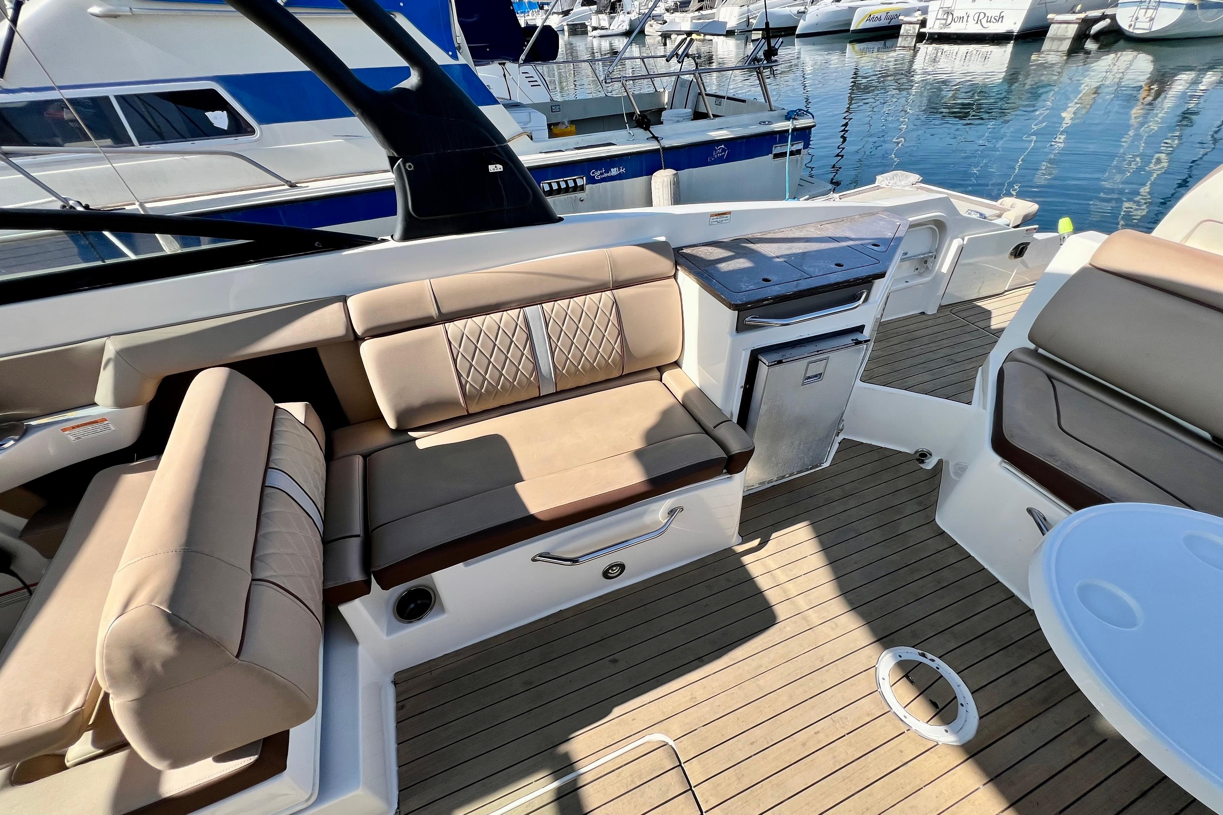 2016 Sea Ray 290 Sundeck Outboard interior with beige seating and wooden deck.