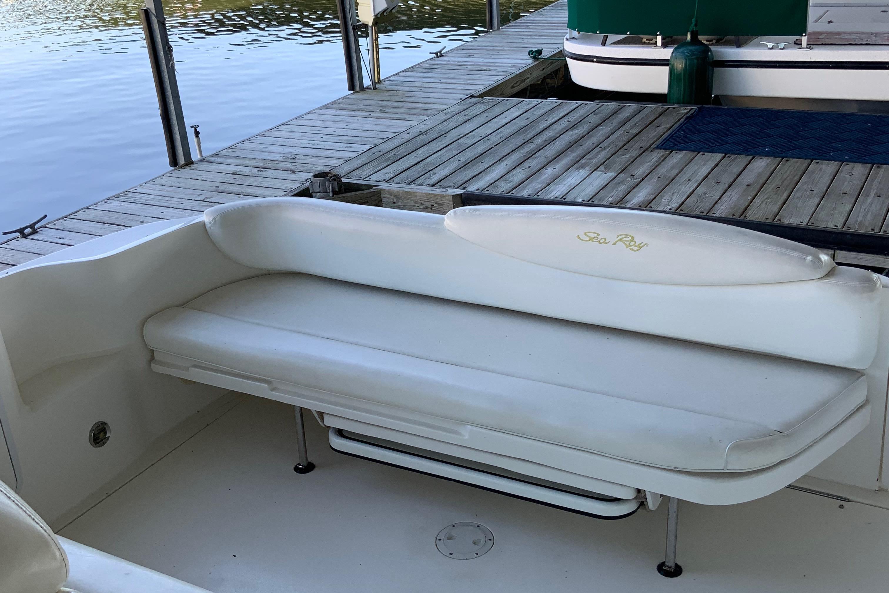 White seating area on a 2000 Sea Ray Sundancer boat docked by the water.