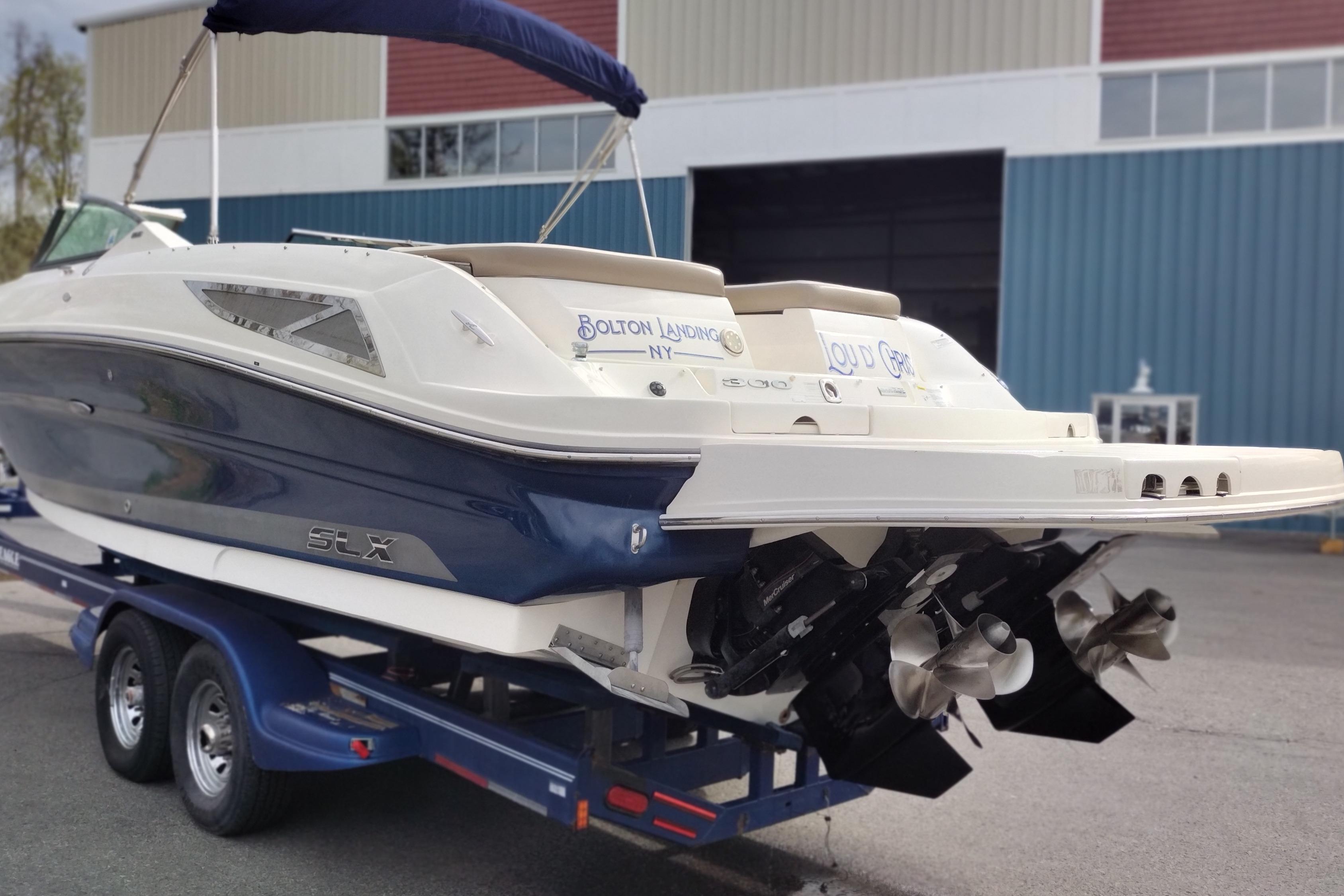 2013 Sea Ray 300 SLX boat on trailer, displayed outdoors near a building.