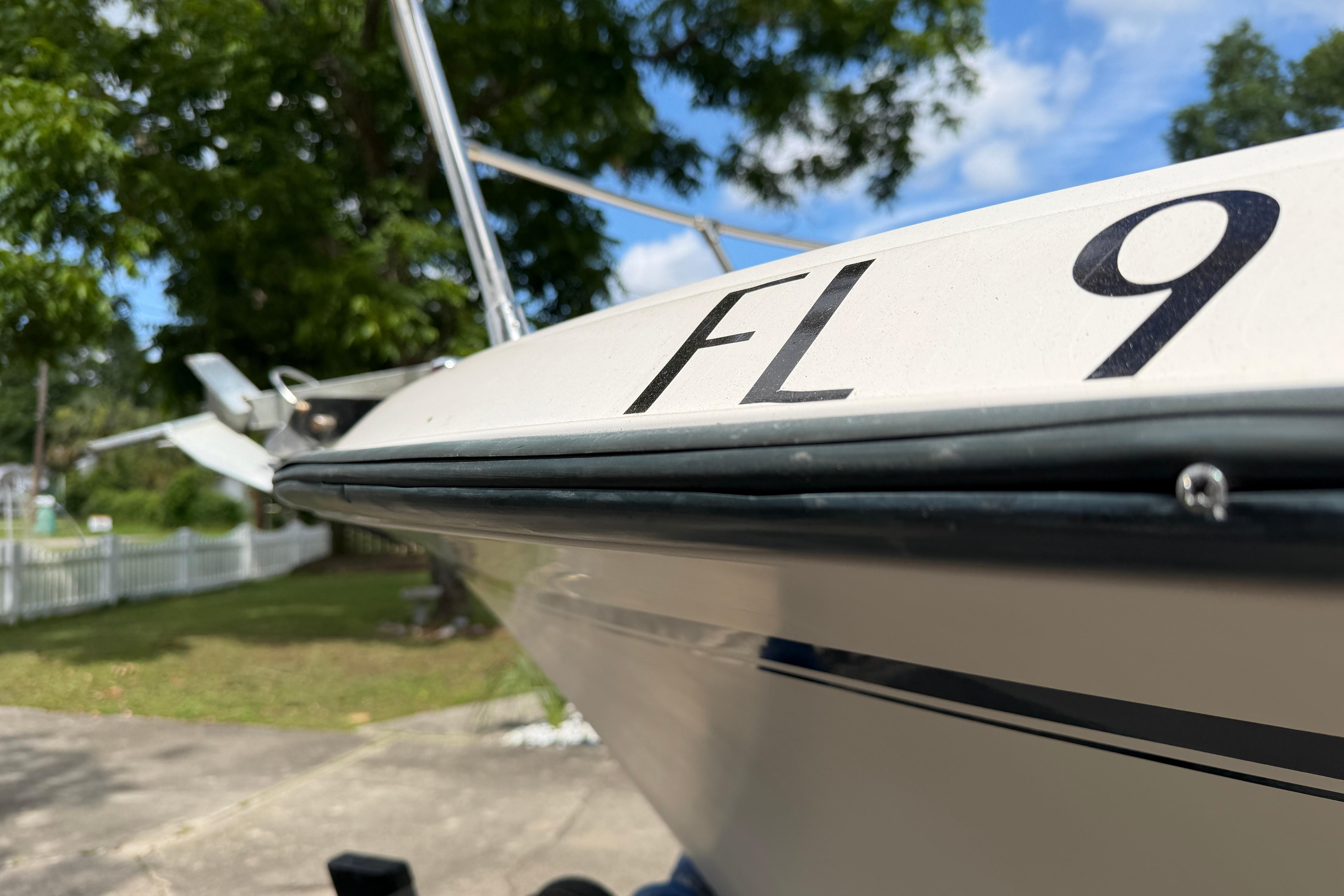 1987 Grady-White Seafarer 226 boat with registration number, parked outdoors.