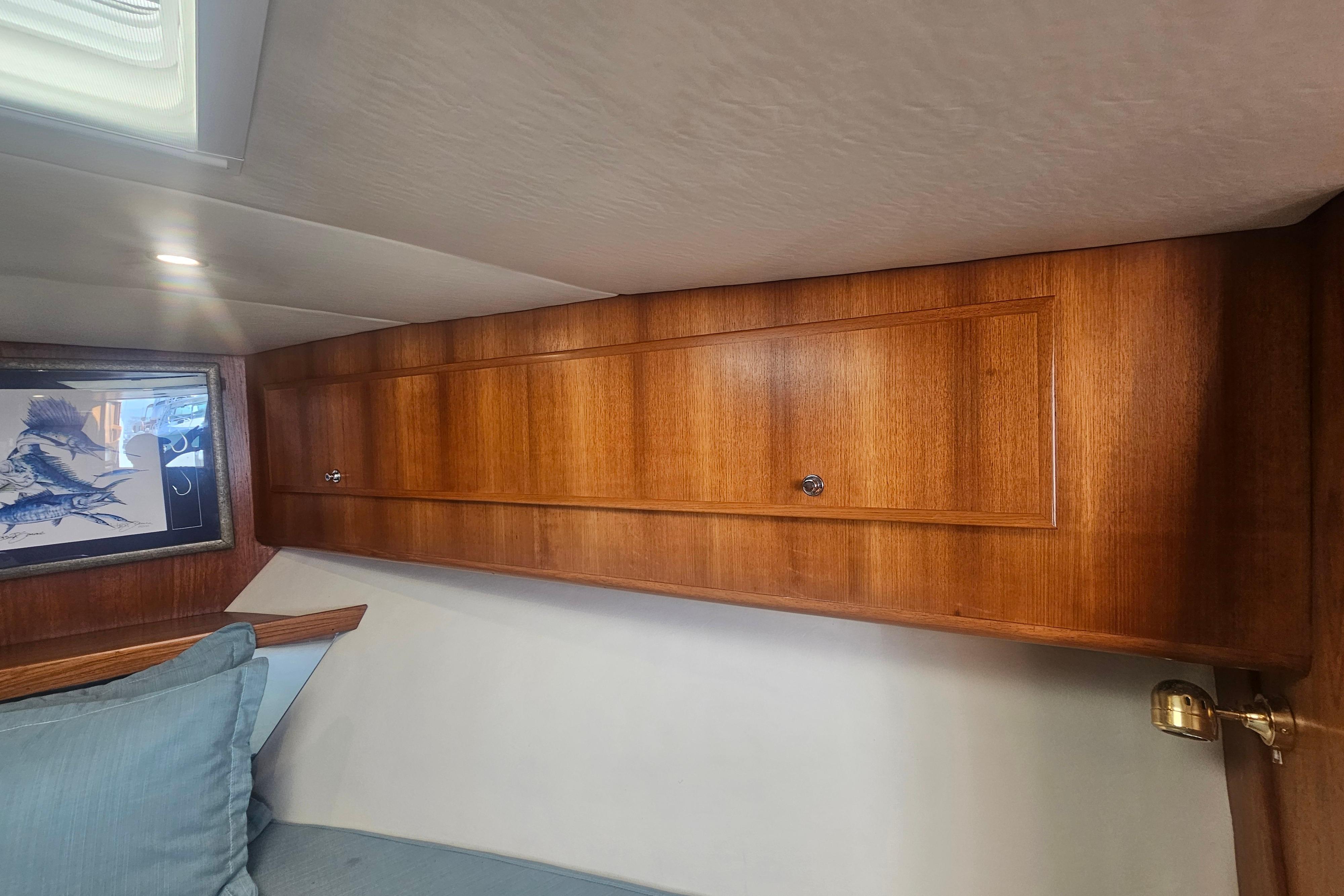 Wooden interior cabin of 2003 Topaz 32 Express boat with artwork and cushions.