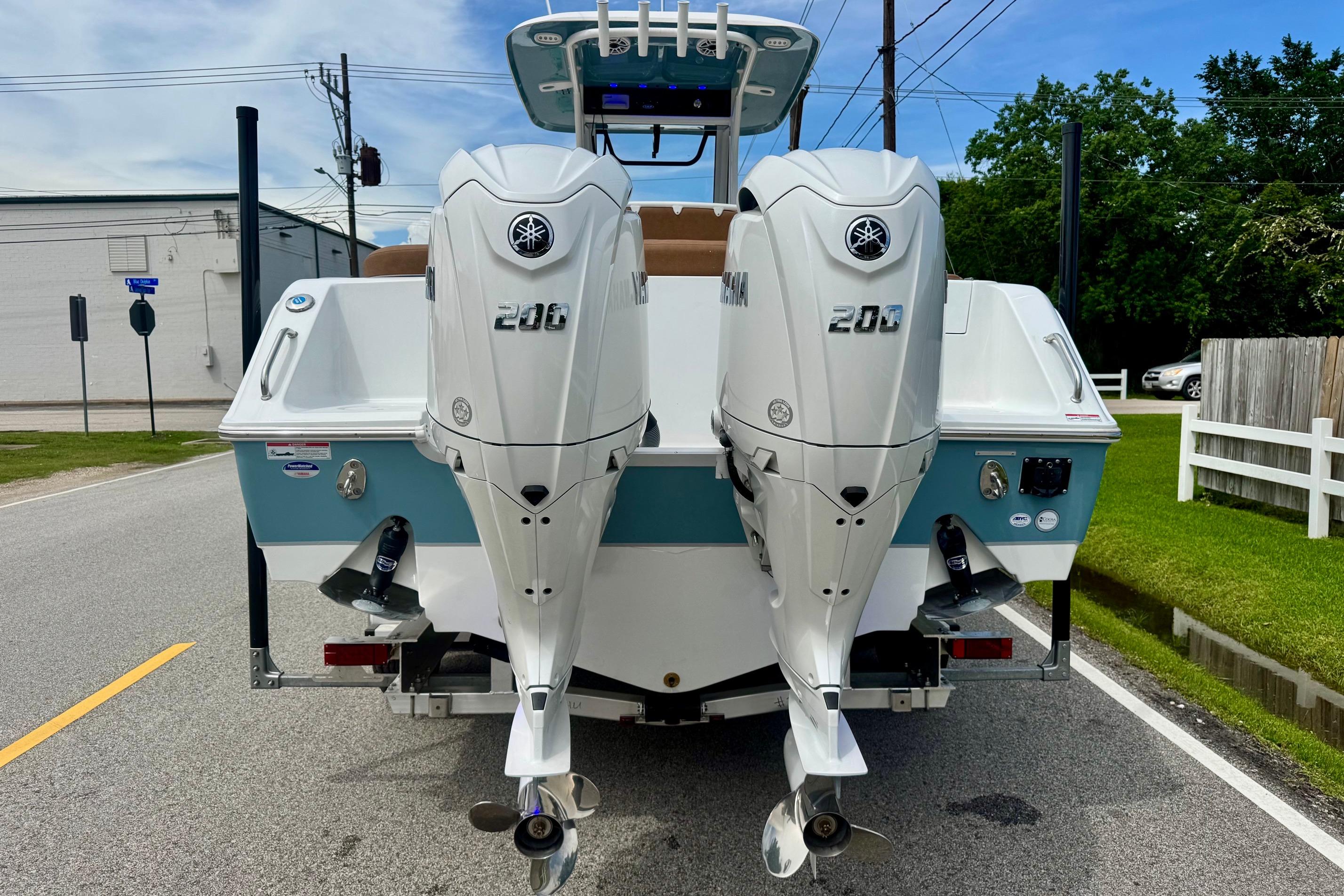 2026 Sea Hunt Ultra 275 SE boat with dual Yamaha 200 engines on a street.