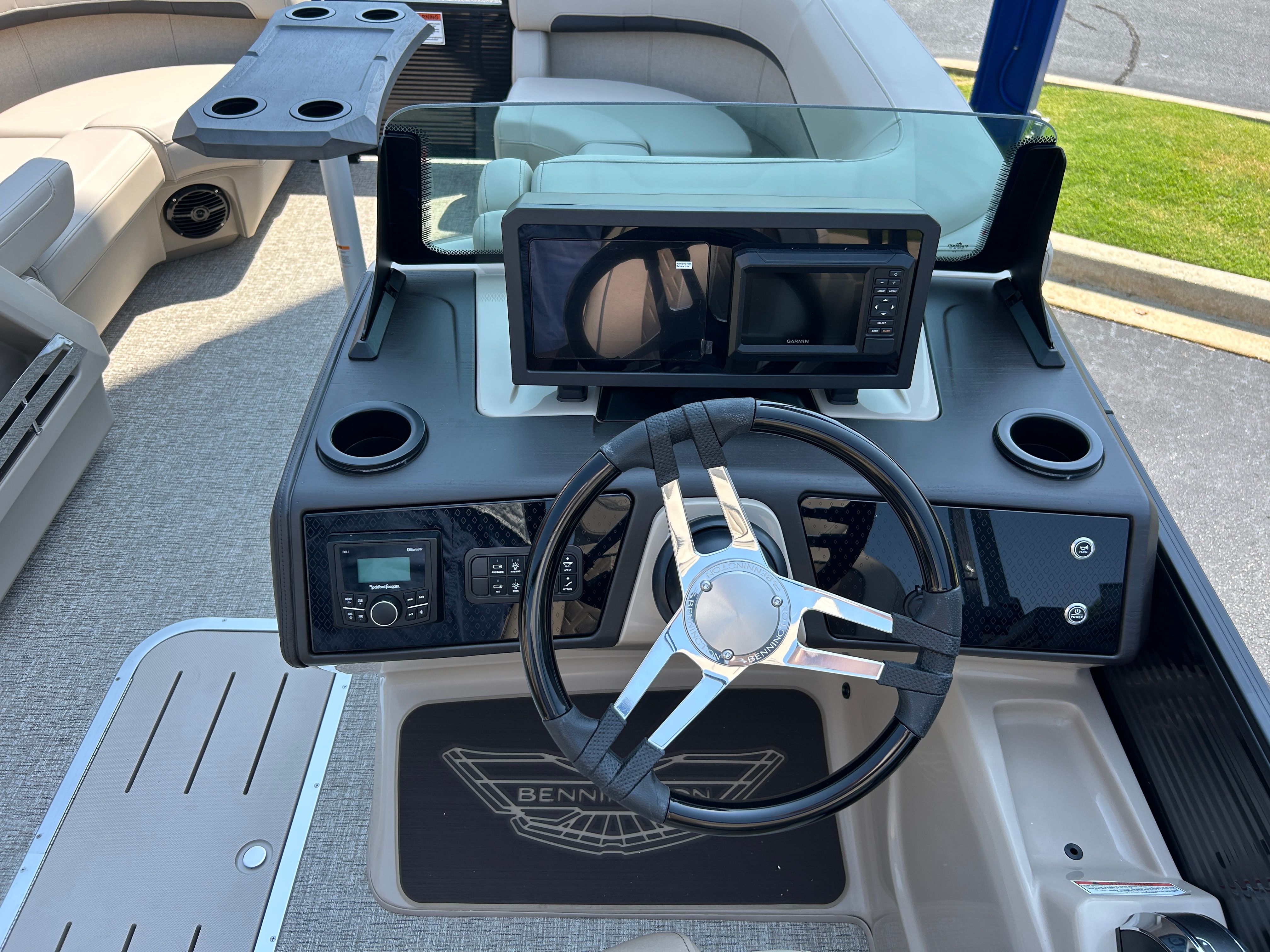 The image shows the helm of a Bennington 22 MFB boat with steering wheel and electronics.