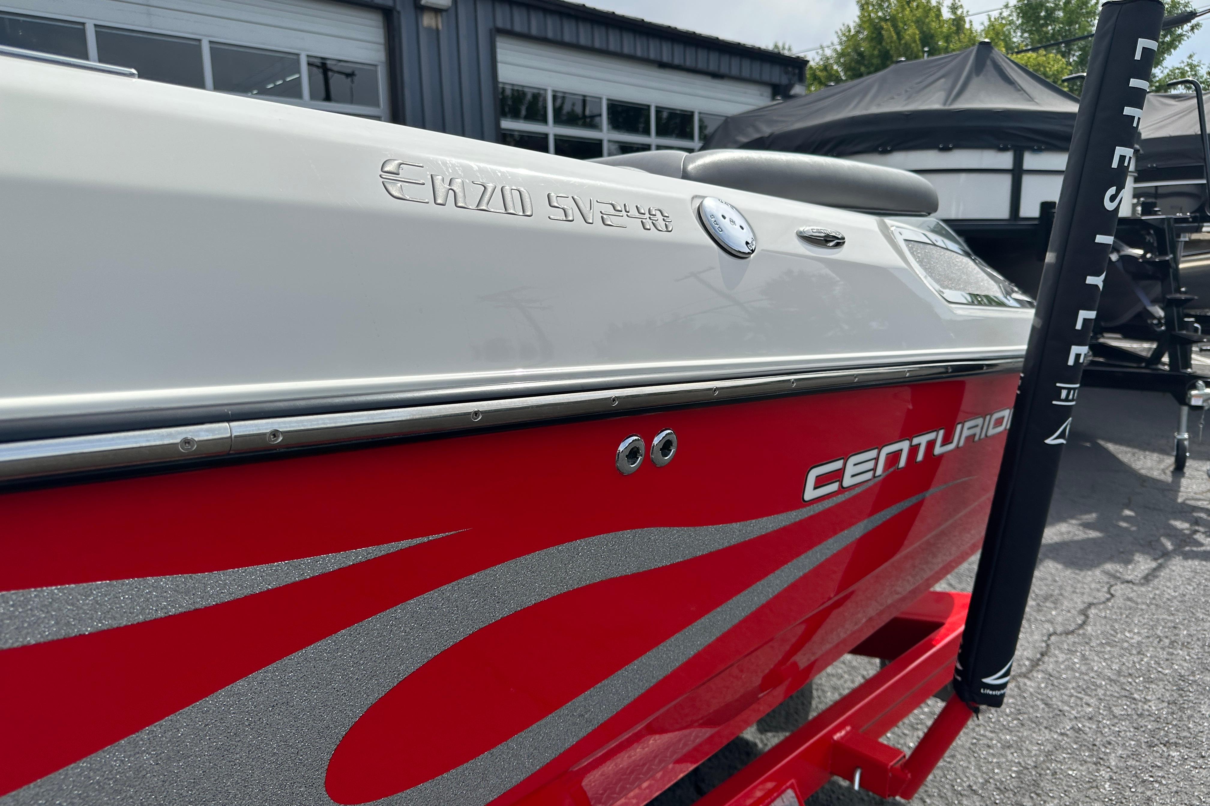 2008 Centurion Enzo SV240 boat with red and silver detailing, parked outdoors.