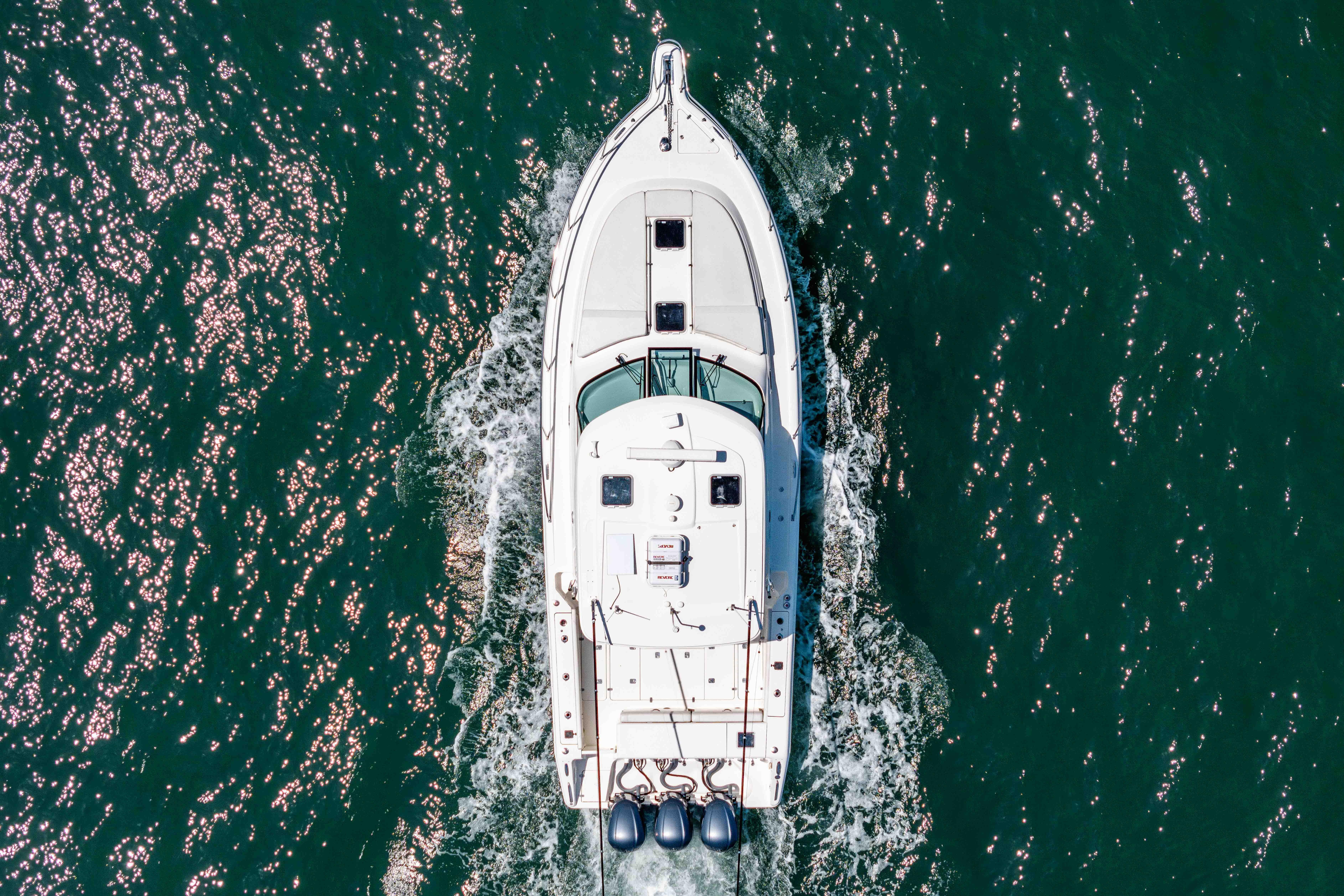 Aerial view of 2022 Pursuit OS 385 Offshore boat cruising on sparkling water.