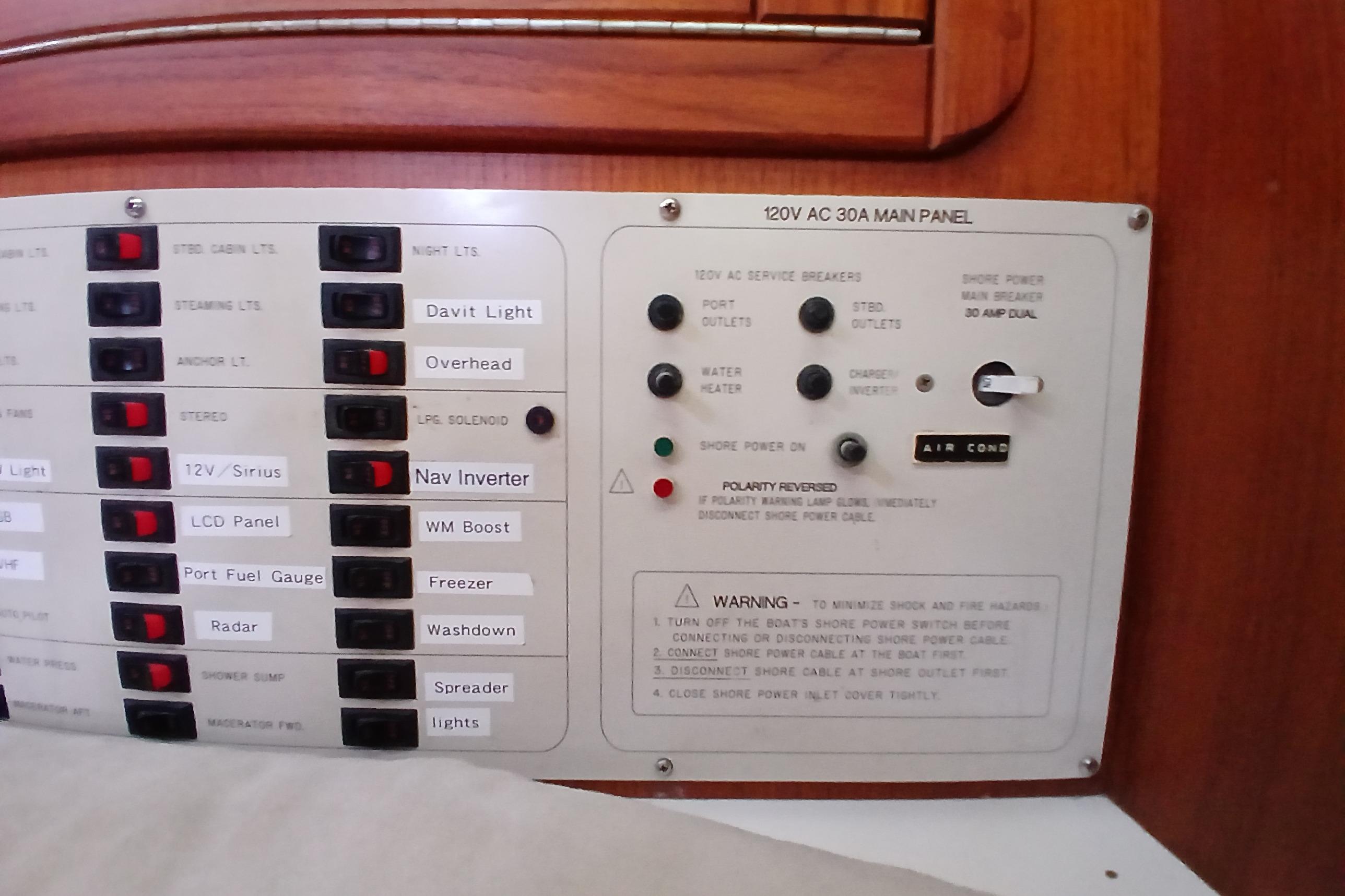 Electrical control panel of a 1995 Catalina 42 MkII sailboat, featuring various switches and warnings.