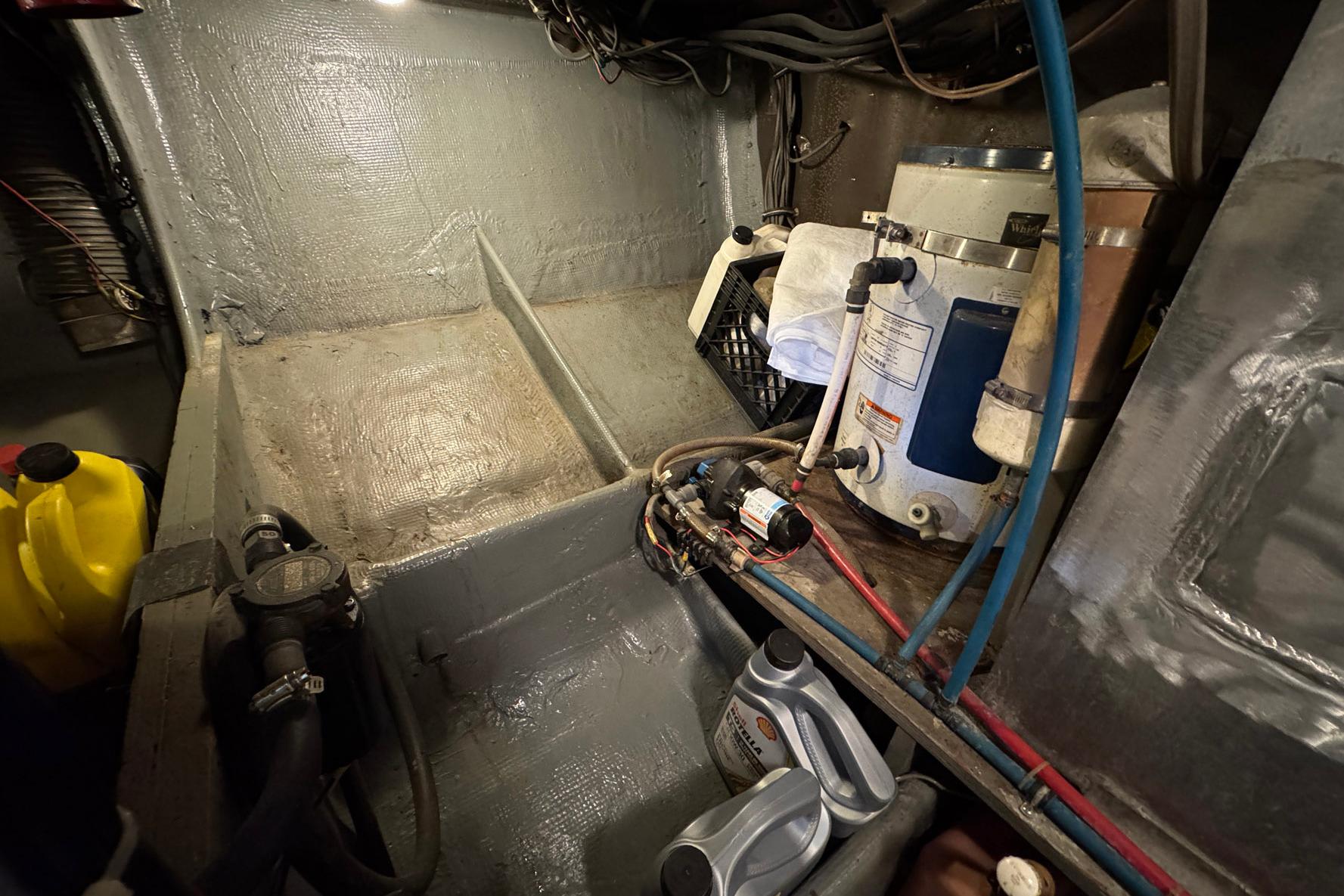 Engine room of a 1979 Bertram 38 Convertible boat, showing equipment and maintenance supplies.