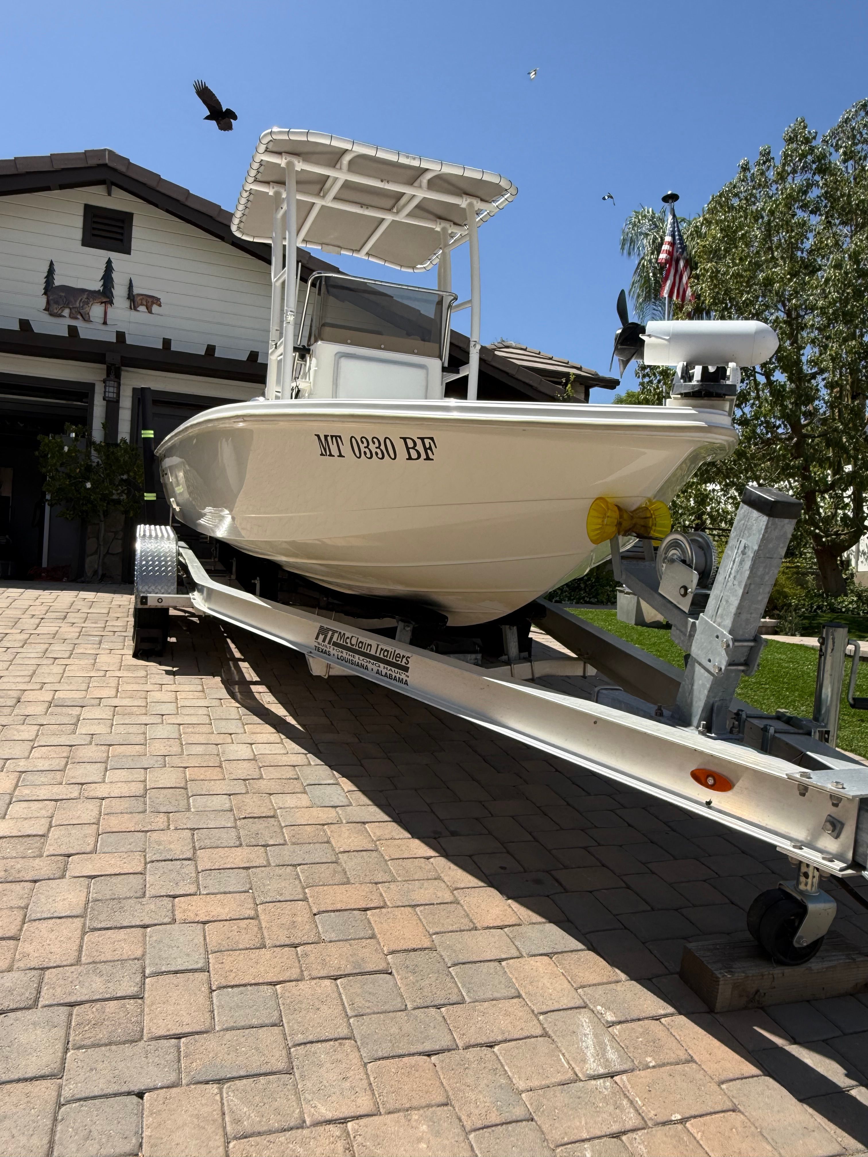 1998 Robalo 2100 Bay Hunter on trailer in front of garage.