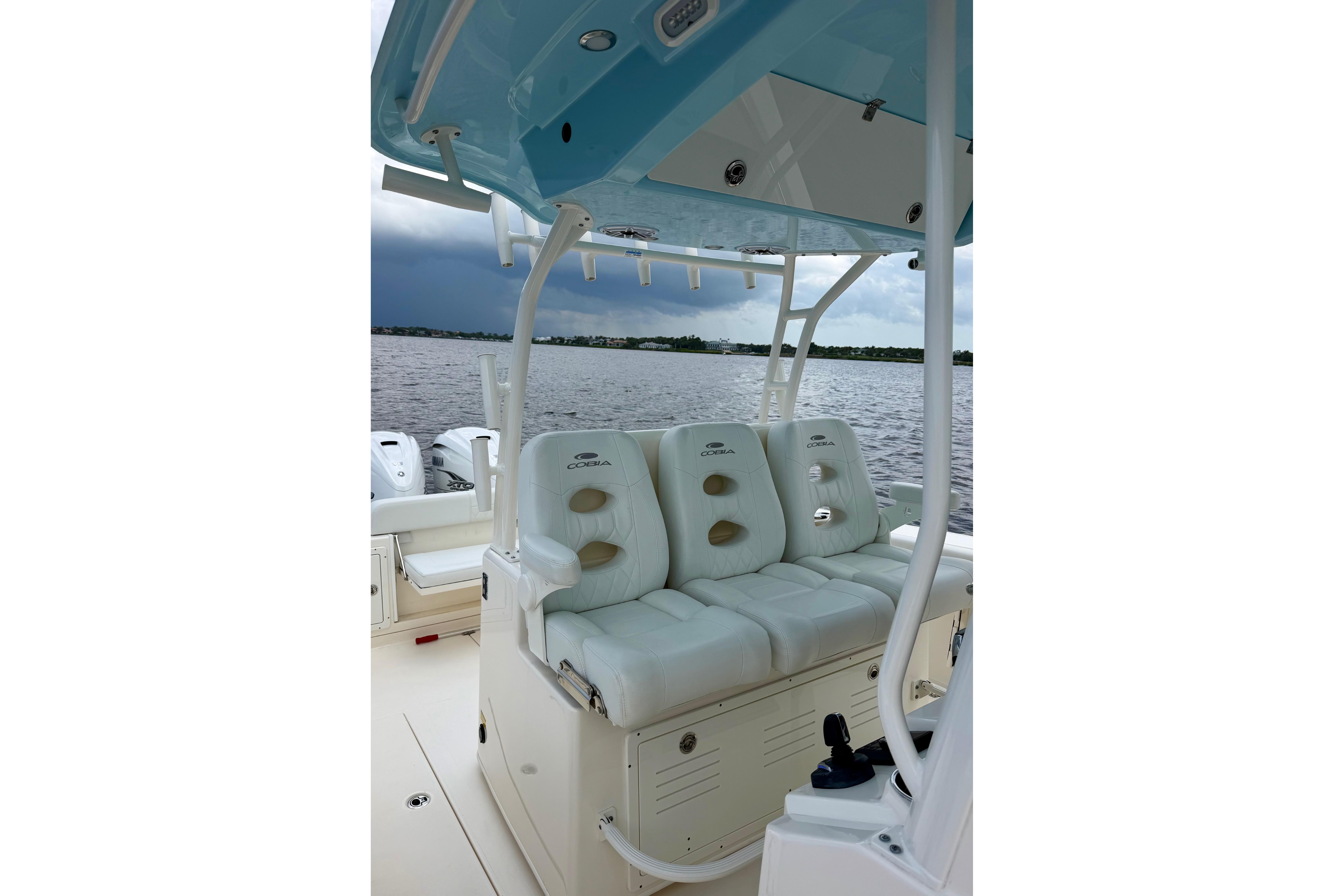2023 Cobia 350 Center Console boat interior with cushioned seating on a calm lake.