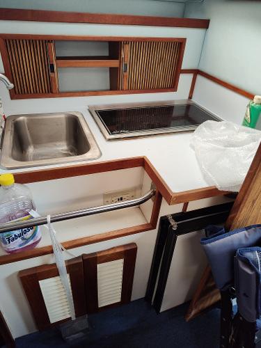 1988 Sea Ray 268 DA boat kitchenette with sink, stove, and storage cabinets.