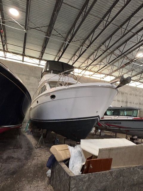A white 2004 Meridian 341 Sedan is on stands in a storage facility.