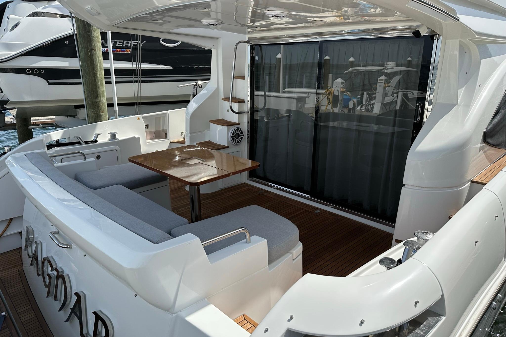 Luxurious 2013 Azimut Fly 53 yacht with elegant seating and wooden table on deck.