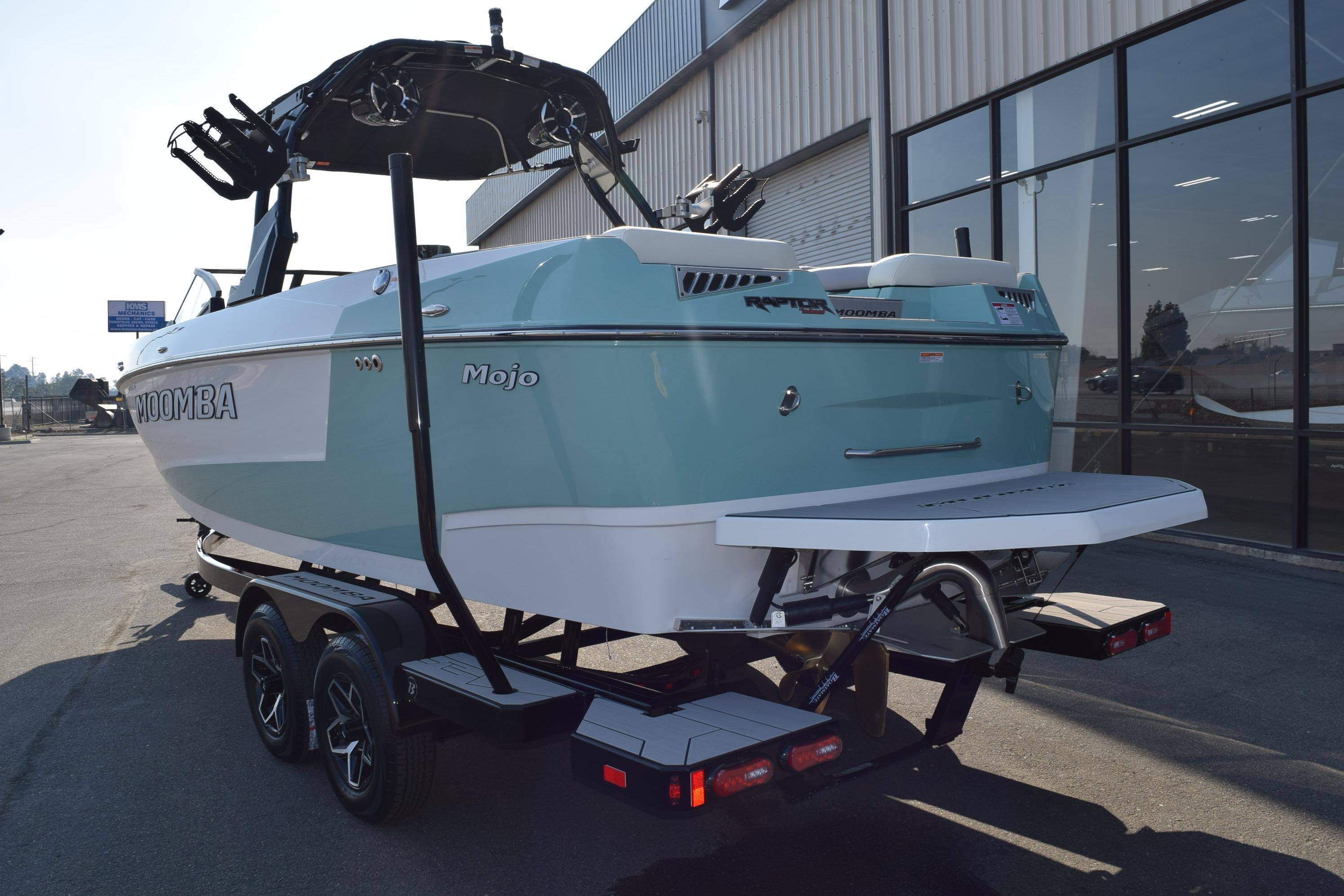 2025 Moomba Mojo boat on trailer, parked near a building, rear view.
