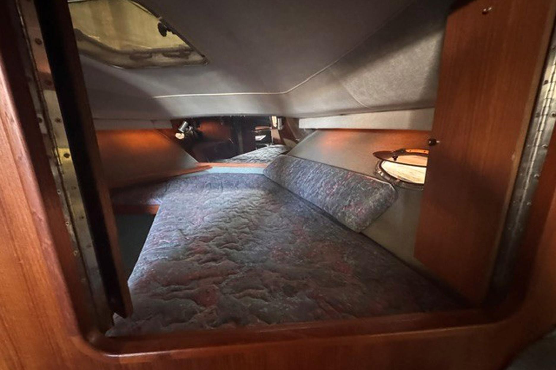 1988 Tiara Yachts 3300 Open cabin interior with cozy sleeping area and wooden accents.
