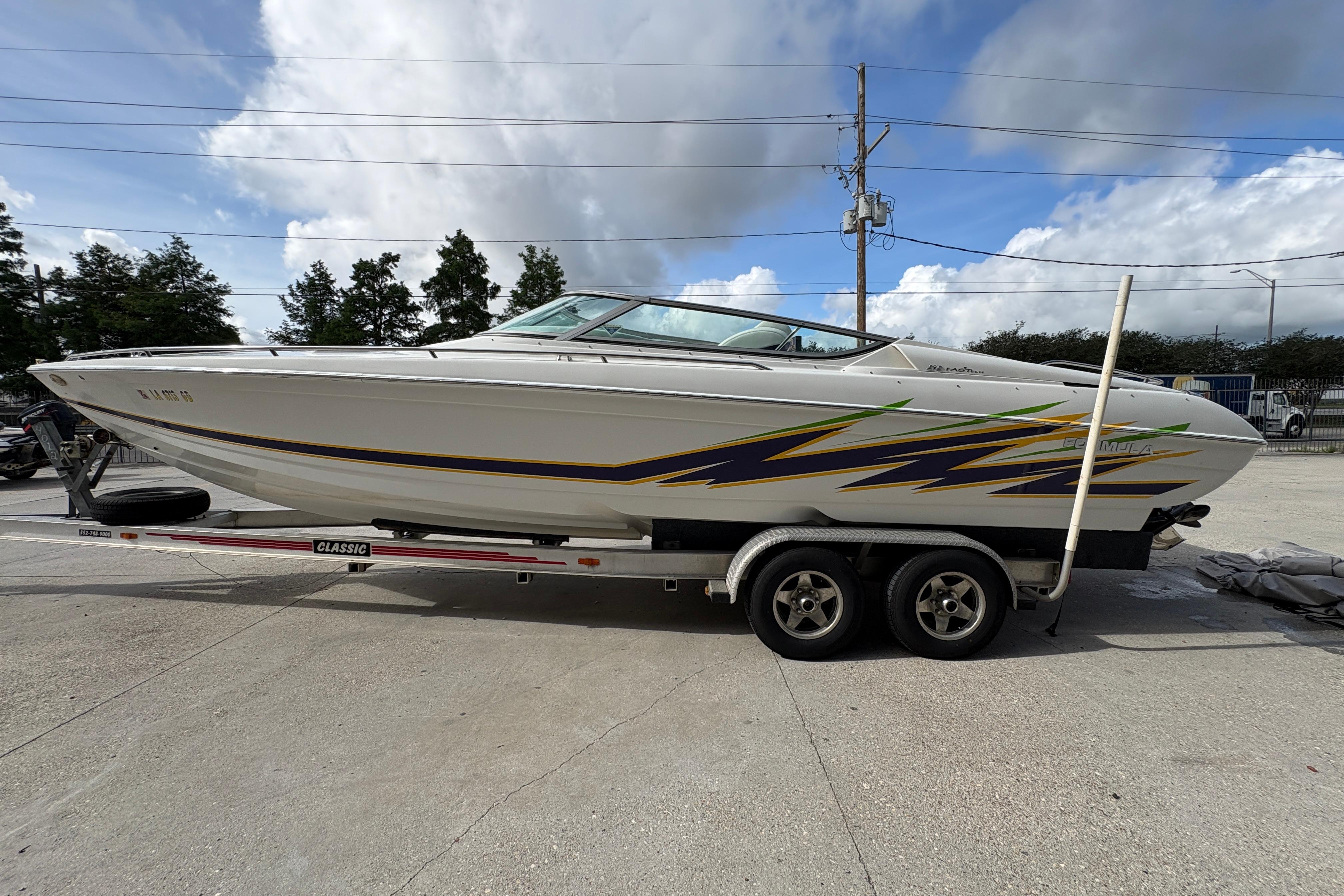 2002 Formula 292 FASTech boat on trailer, featuring sleek design and vibrant graphics.