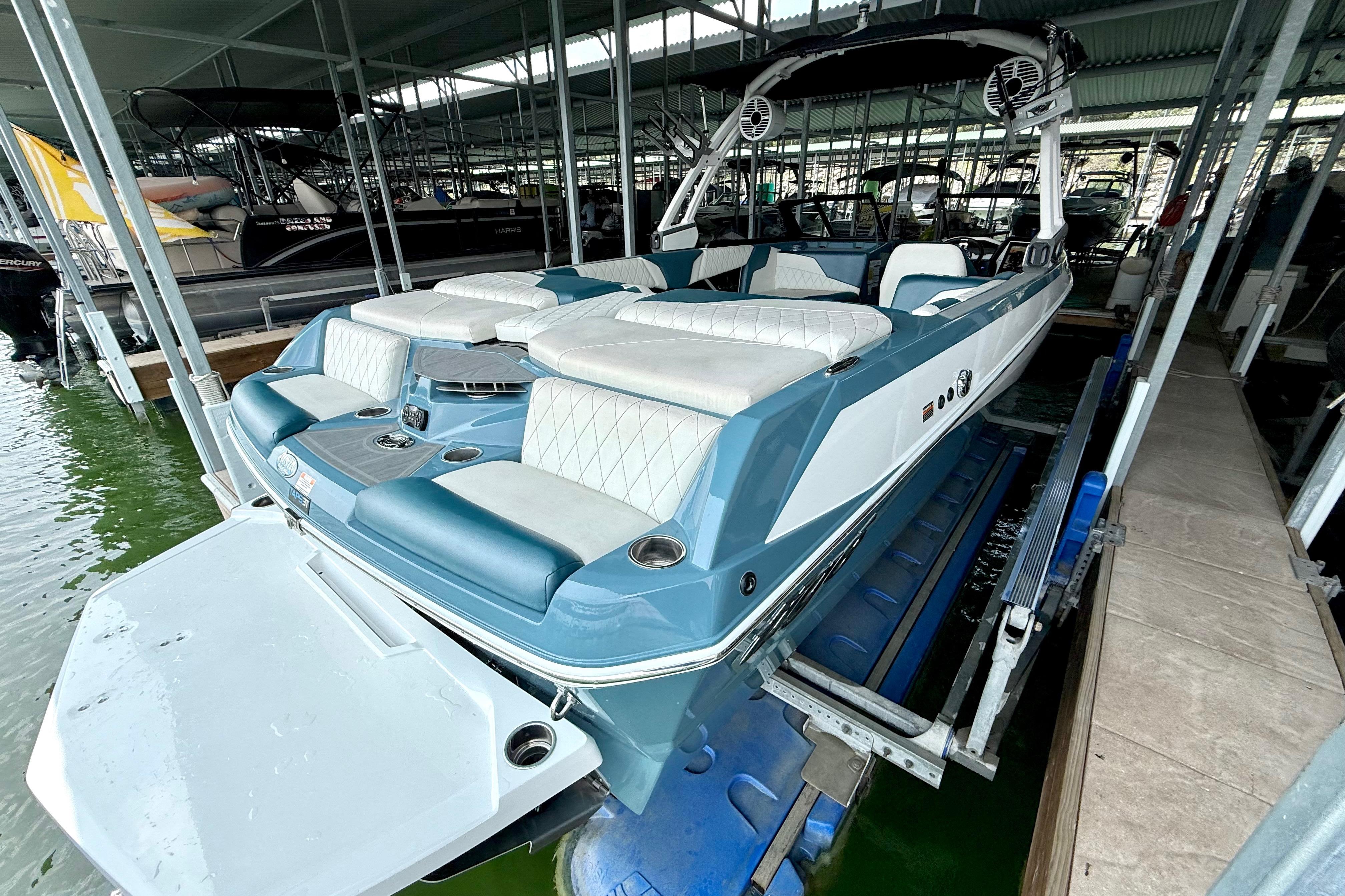 2021 Tige Z3 boat with white and blue seating, docked in a marina.