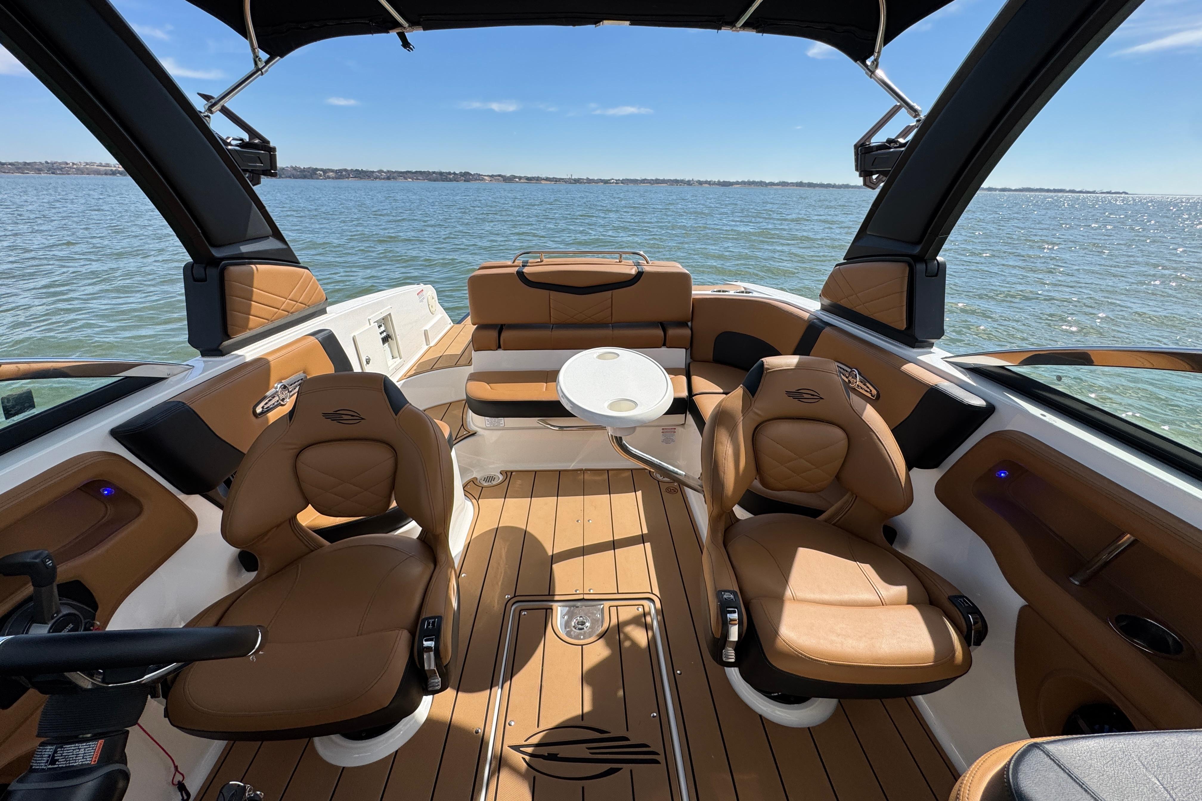 Interior of 2023 Chaparral 26 Surf boat with luxurious seating and scenic water view.
