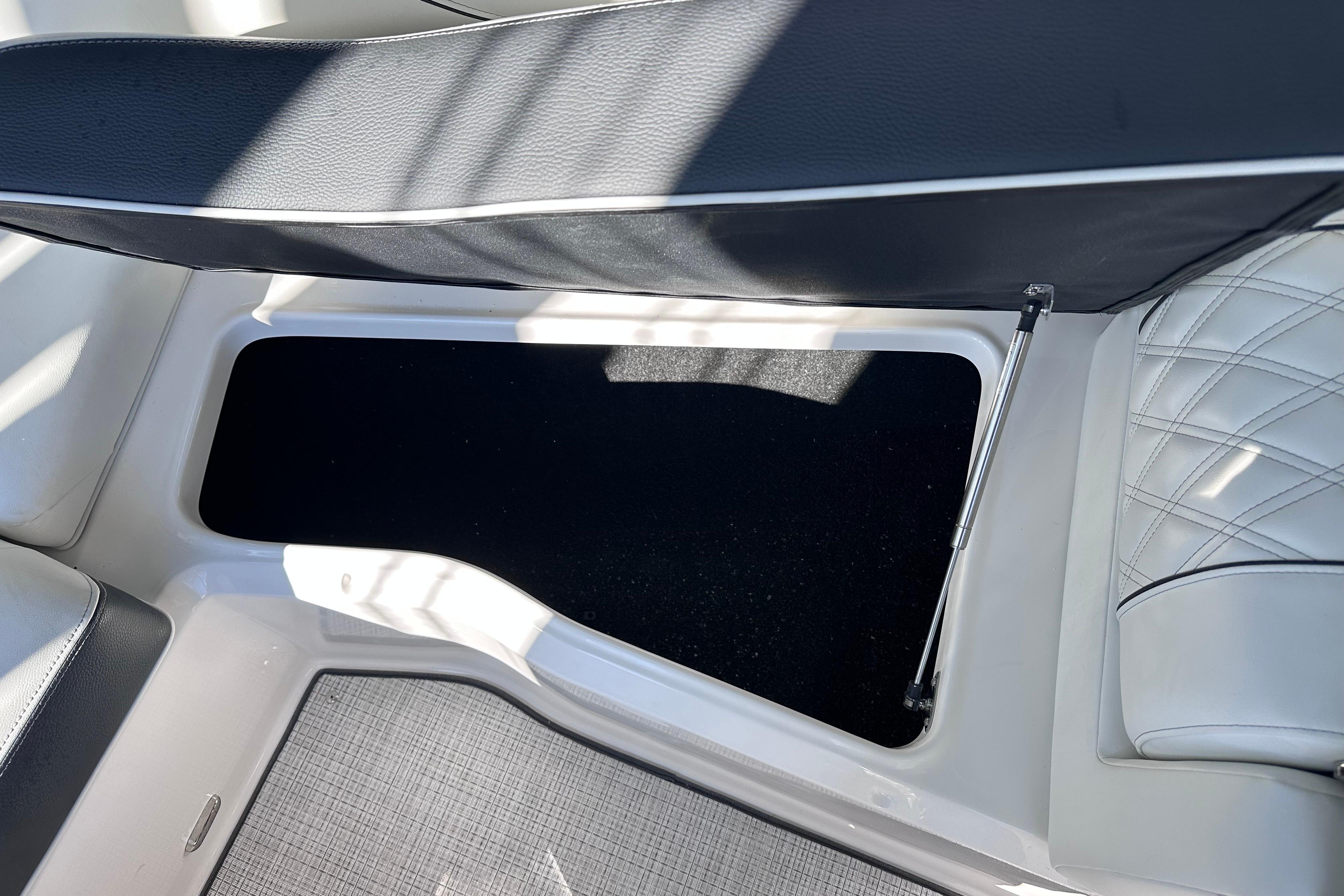 2026 Regal LX4 boat interior storage compartment with cushioned seating and hydraulic lift.